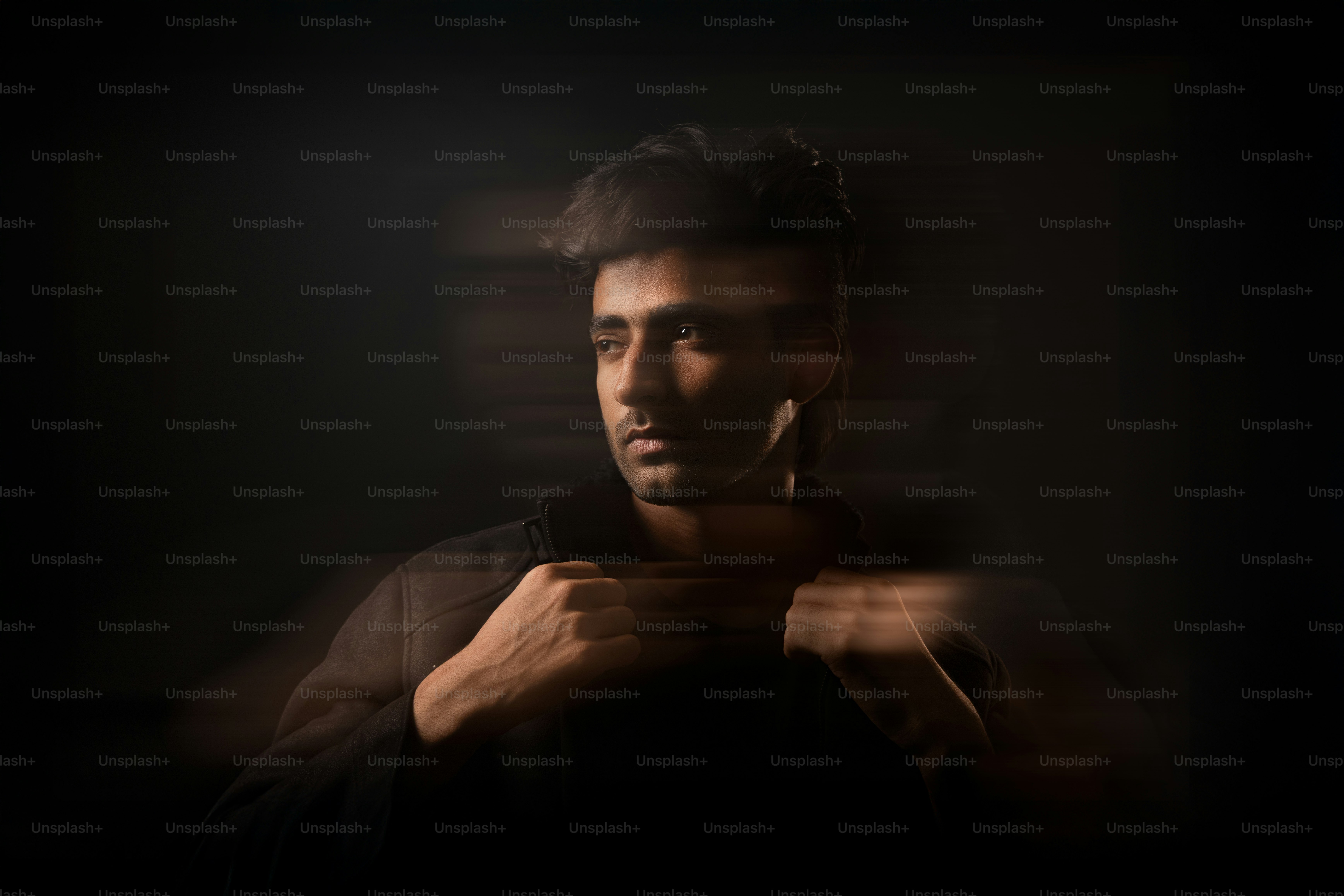 Ein Mann posiert unter dramatischer Beleuchtung.