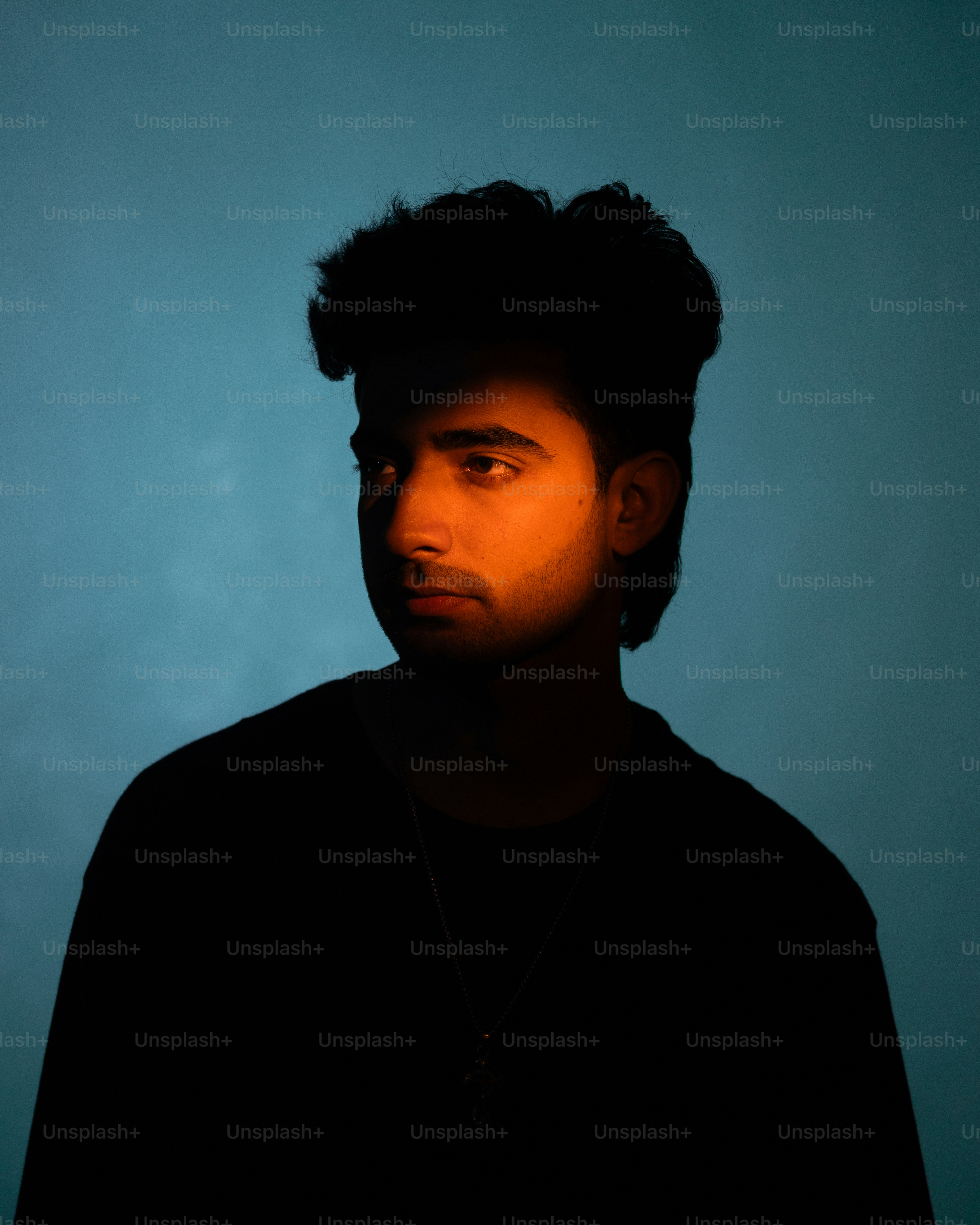 Ein Mann schaut mit dramatischem Licht weg.