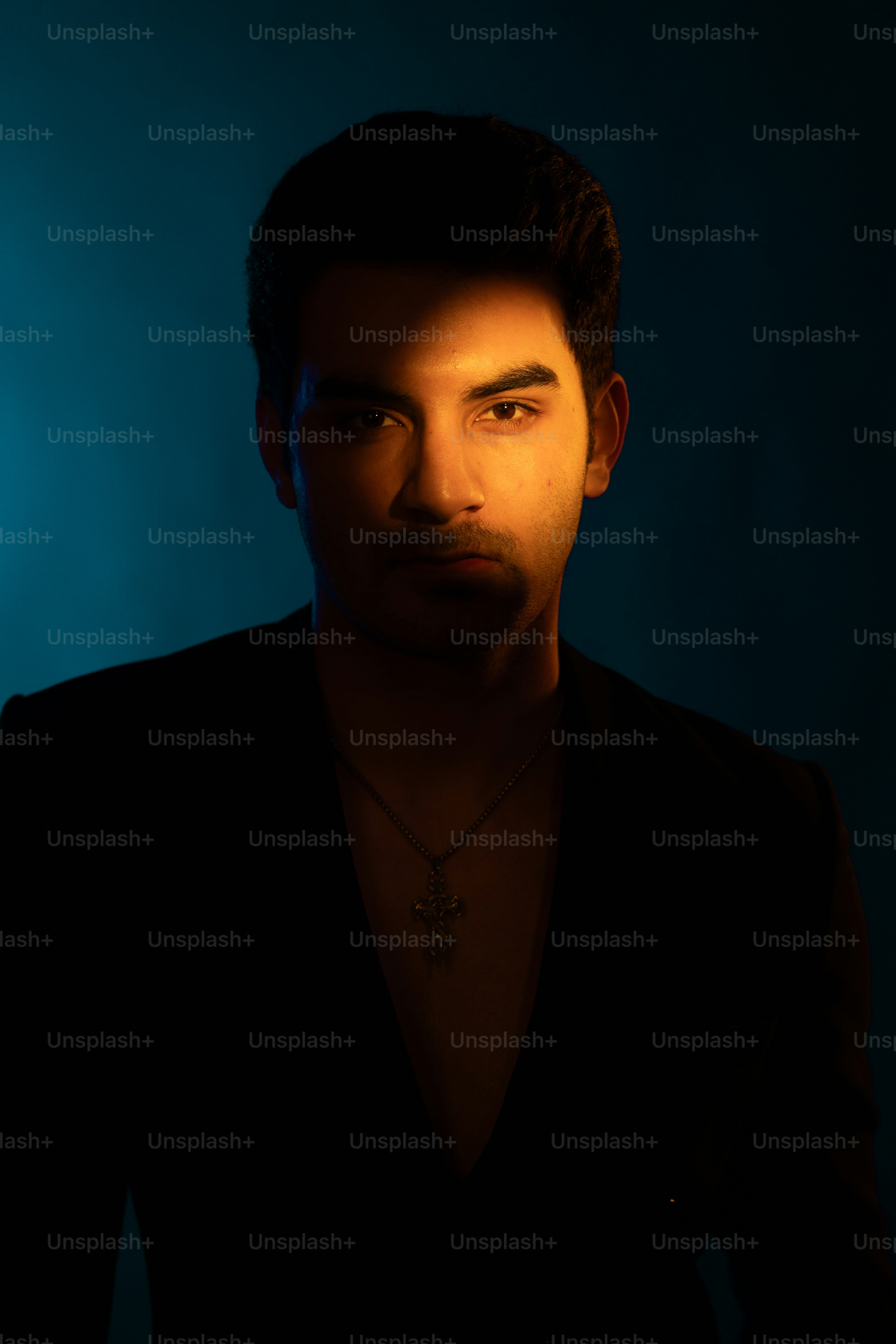Un hombre posa bajo una iluminación creativa.