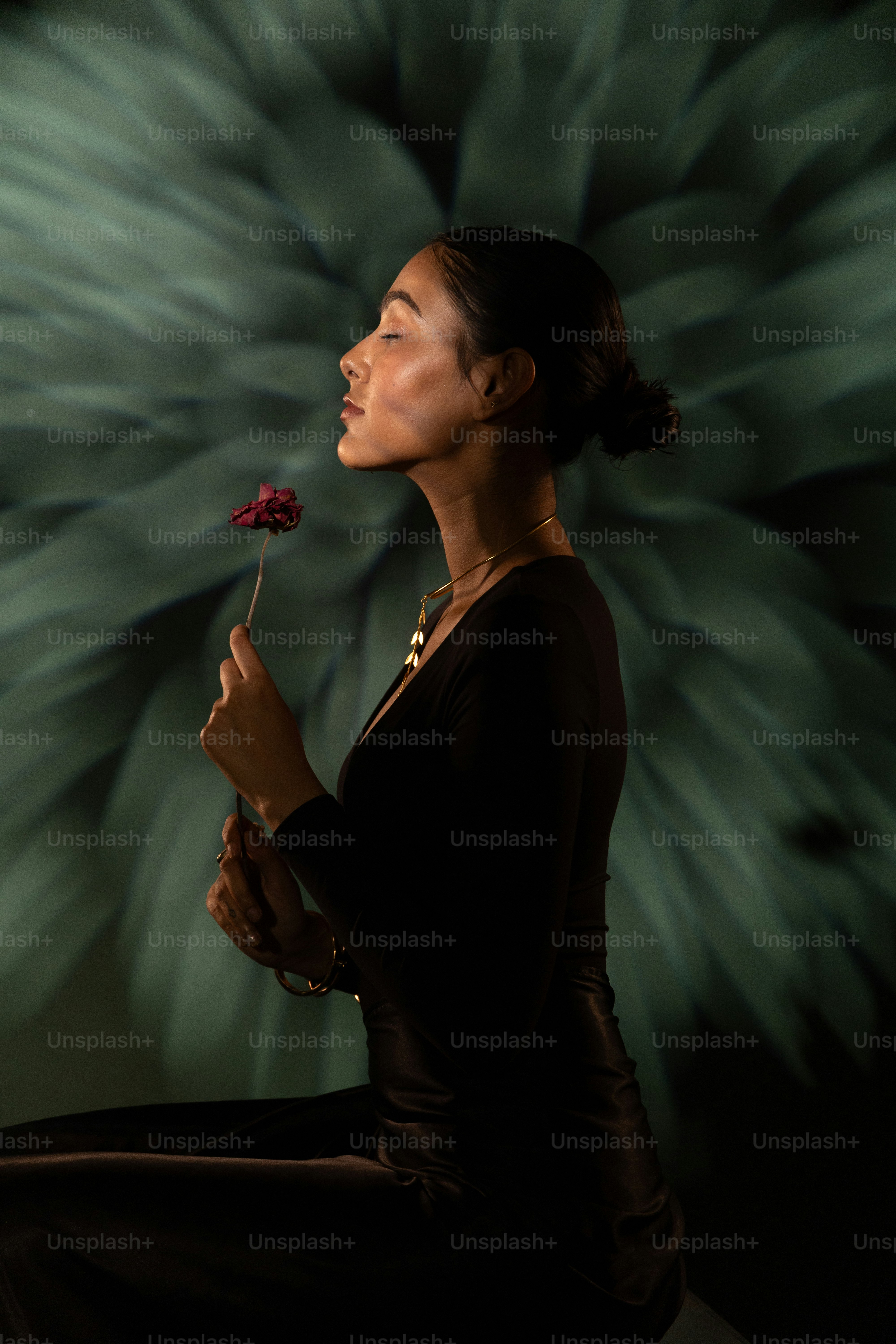 La mujer disfruta de la fragancia de una sola flor.