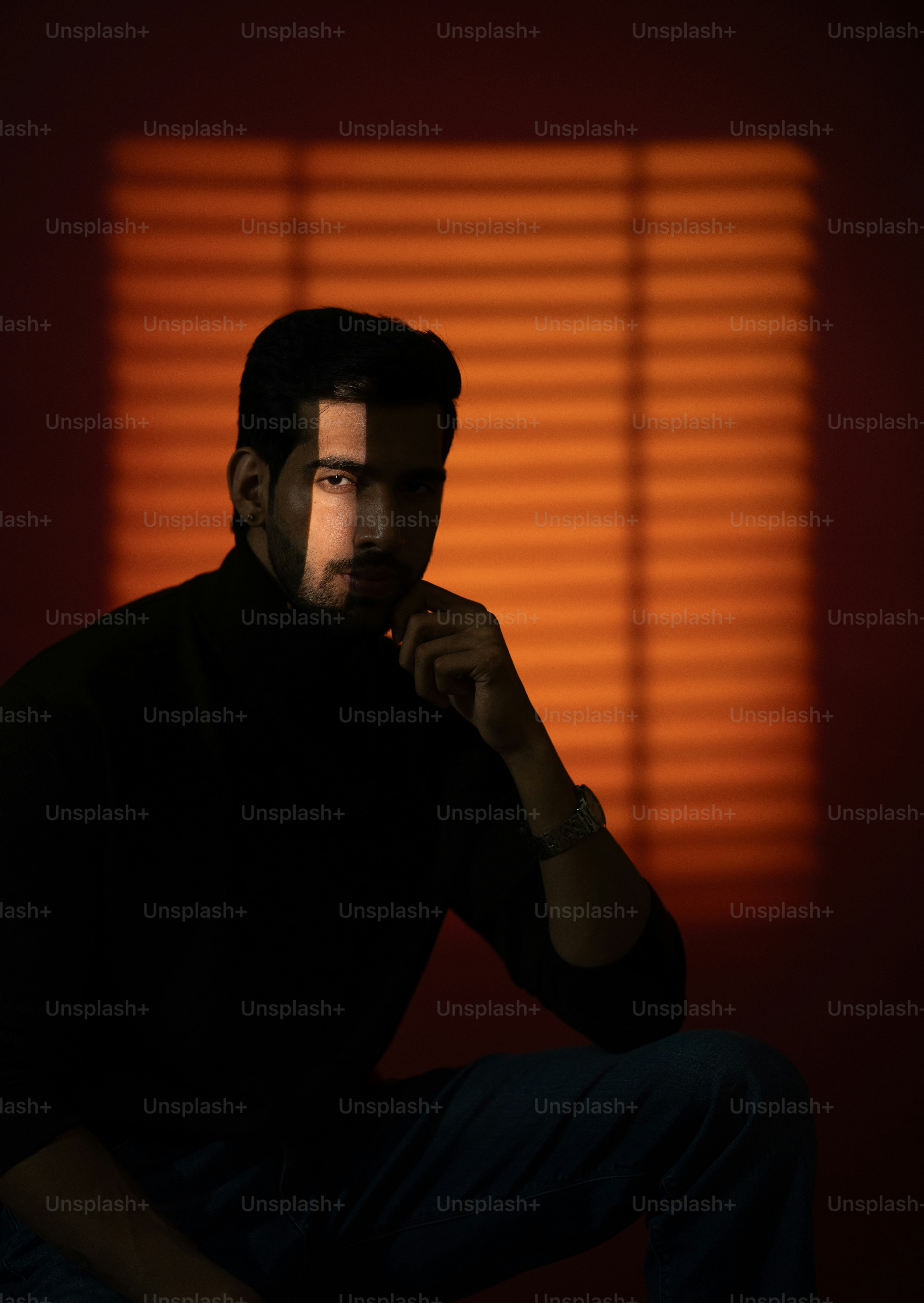 El hombre posa en una iluminación dramática con una expresión pensativa.