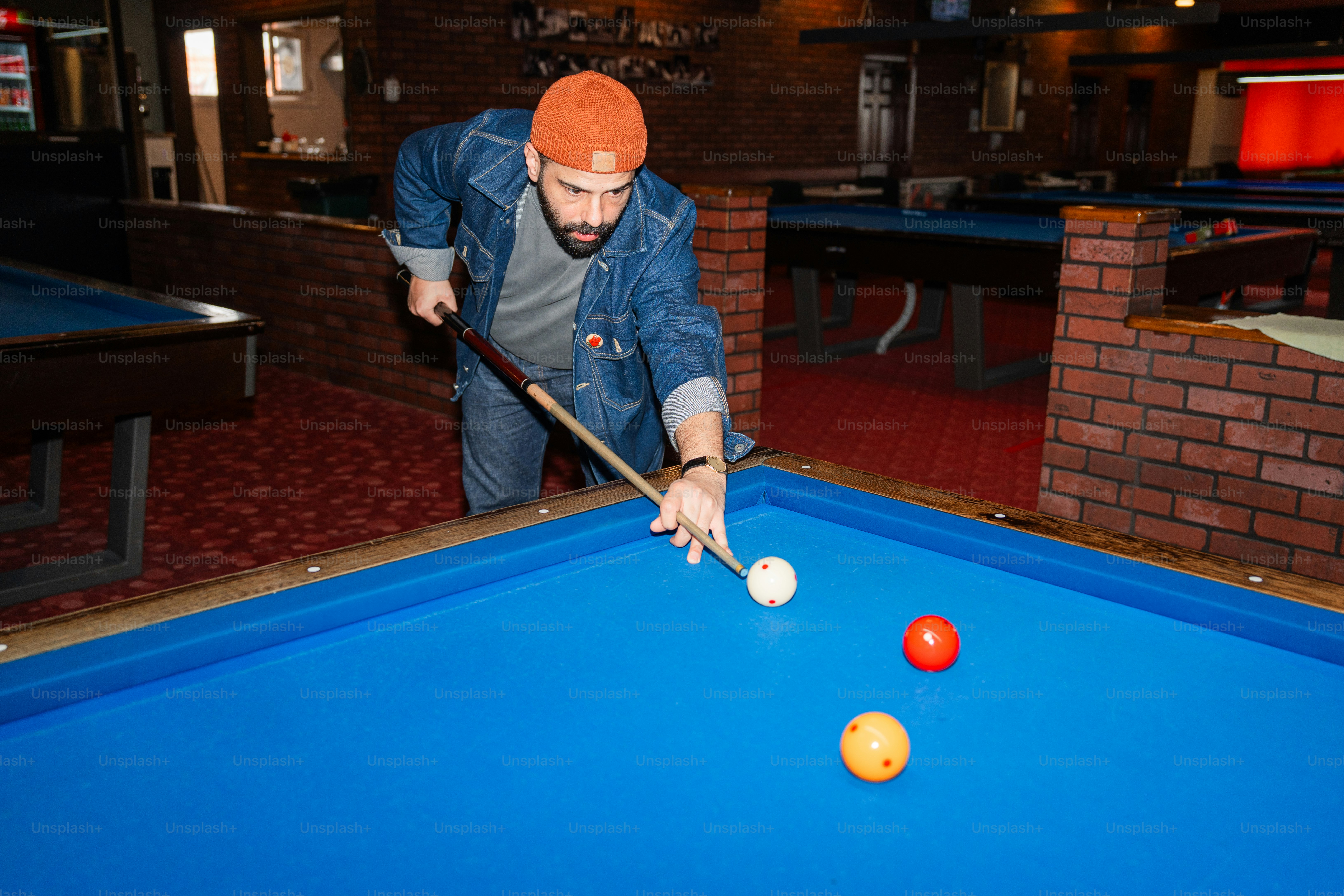 Man is about to make a billiards shot.