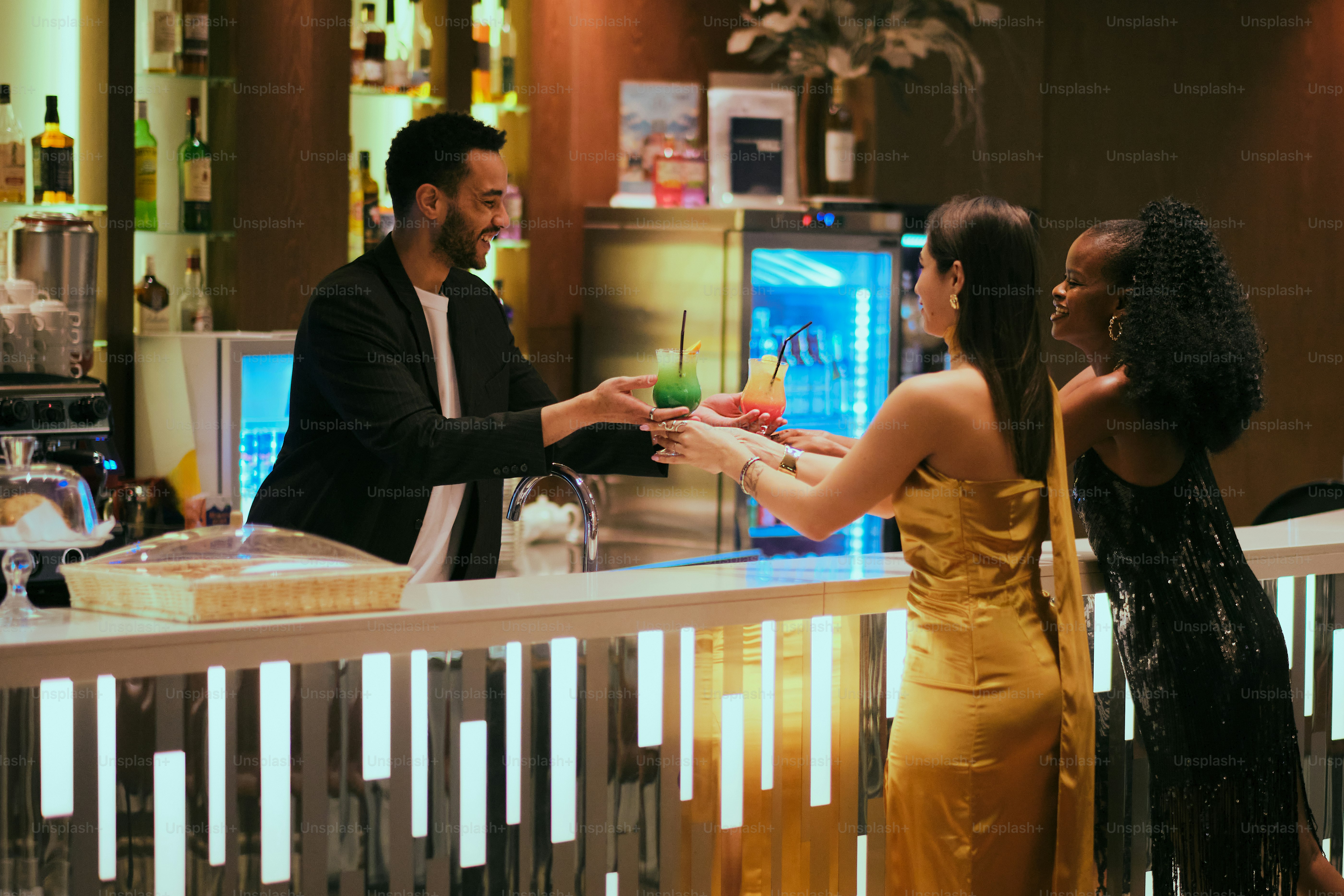People enjoying drinks in dimly lit, stylish cocktail bar