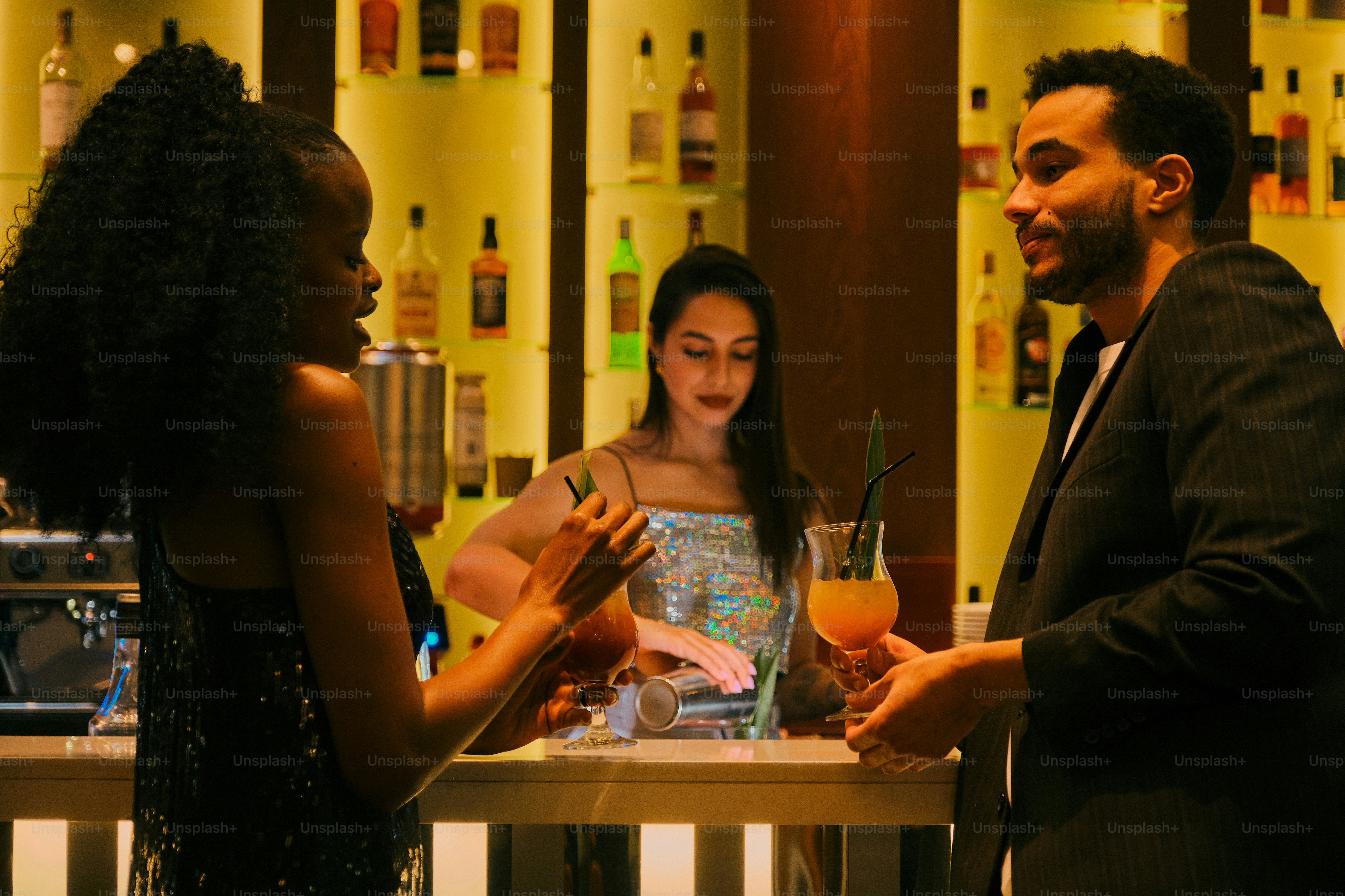 A woman sits at a bar with a drink. photo – People Image on Unsplash