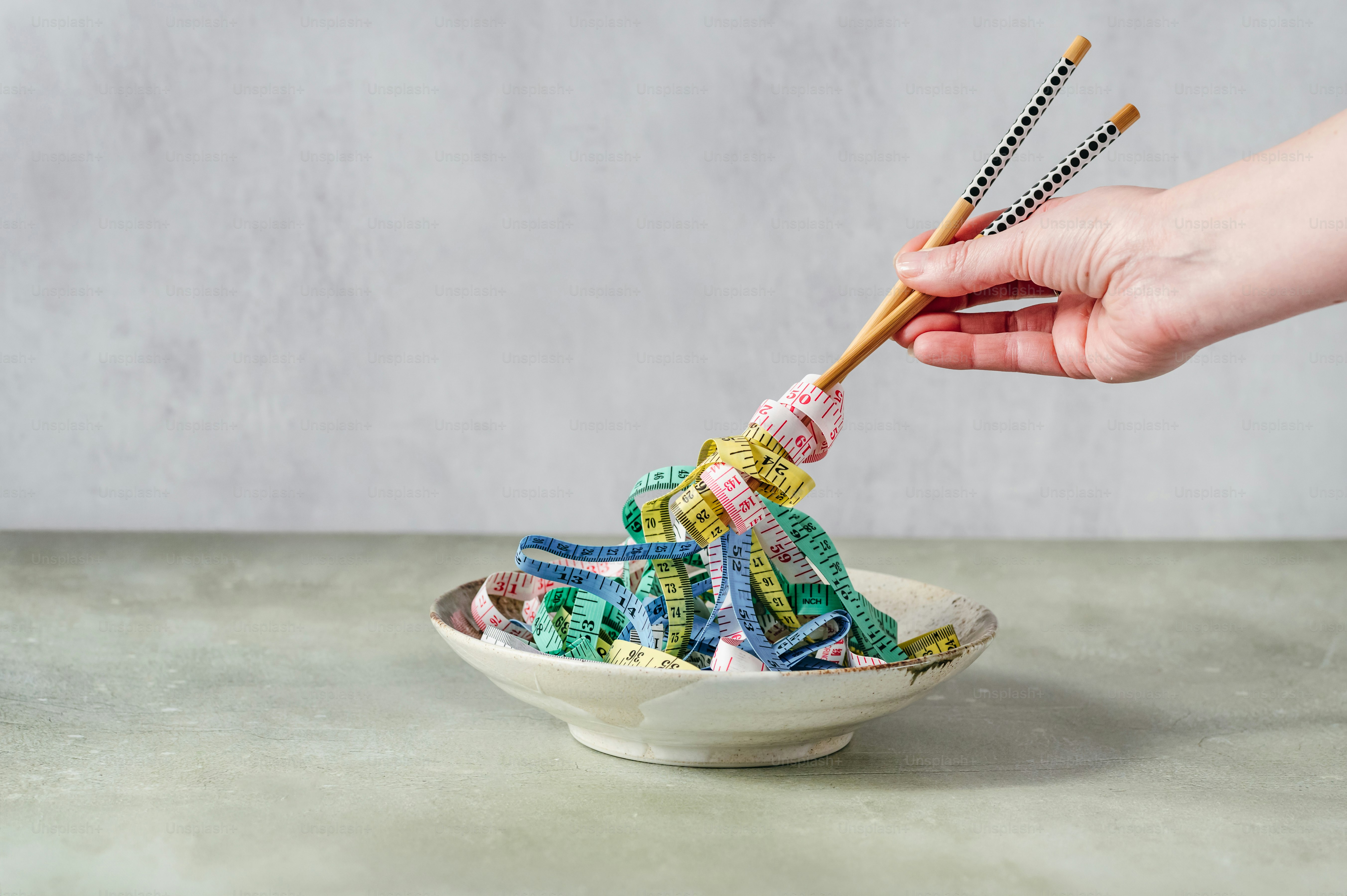 Someone is eating colorful ribbons from a bowl.
