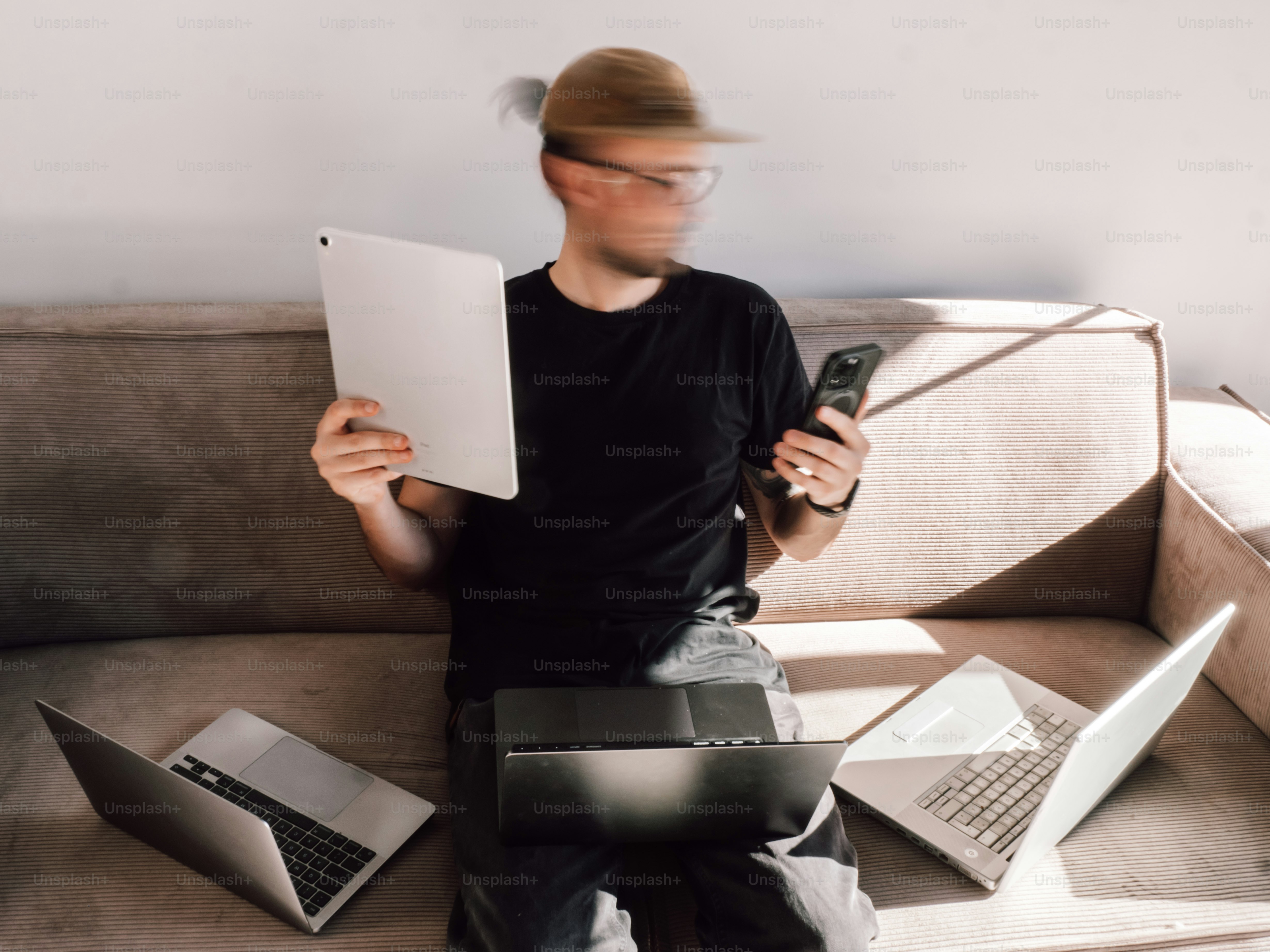 Man is multitasking with many devices at once.