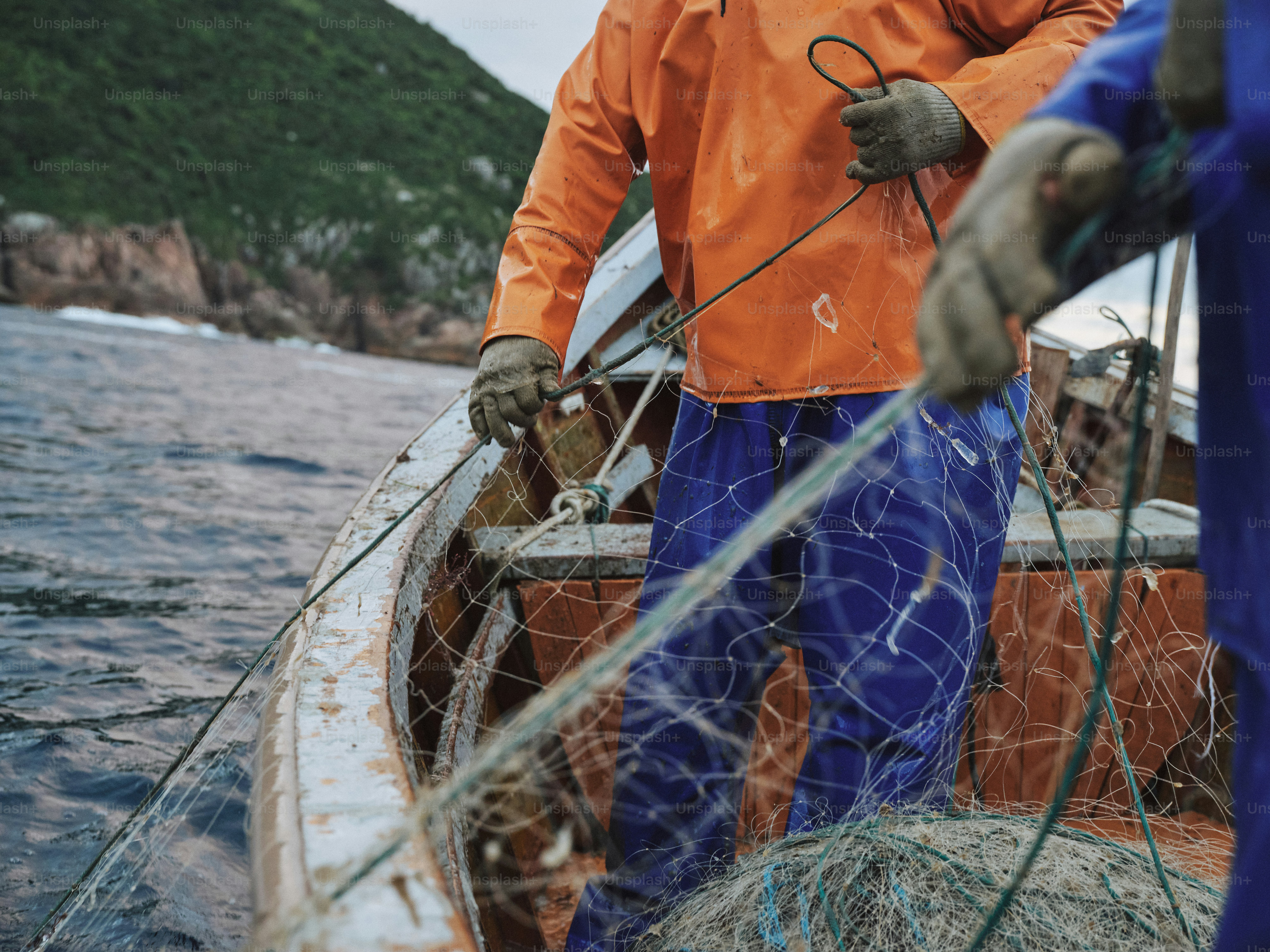 Fishermen are pulling a fishing net onto their boat