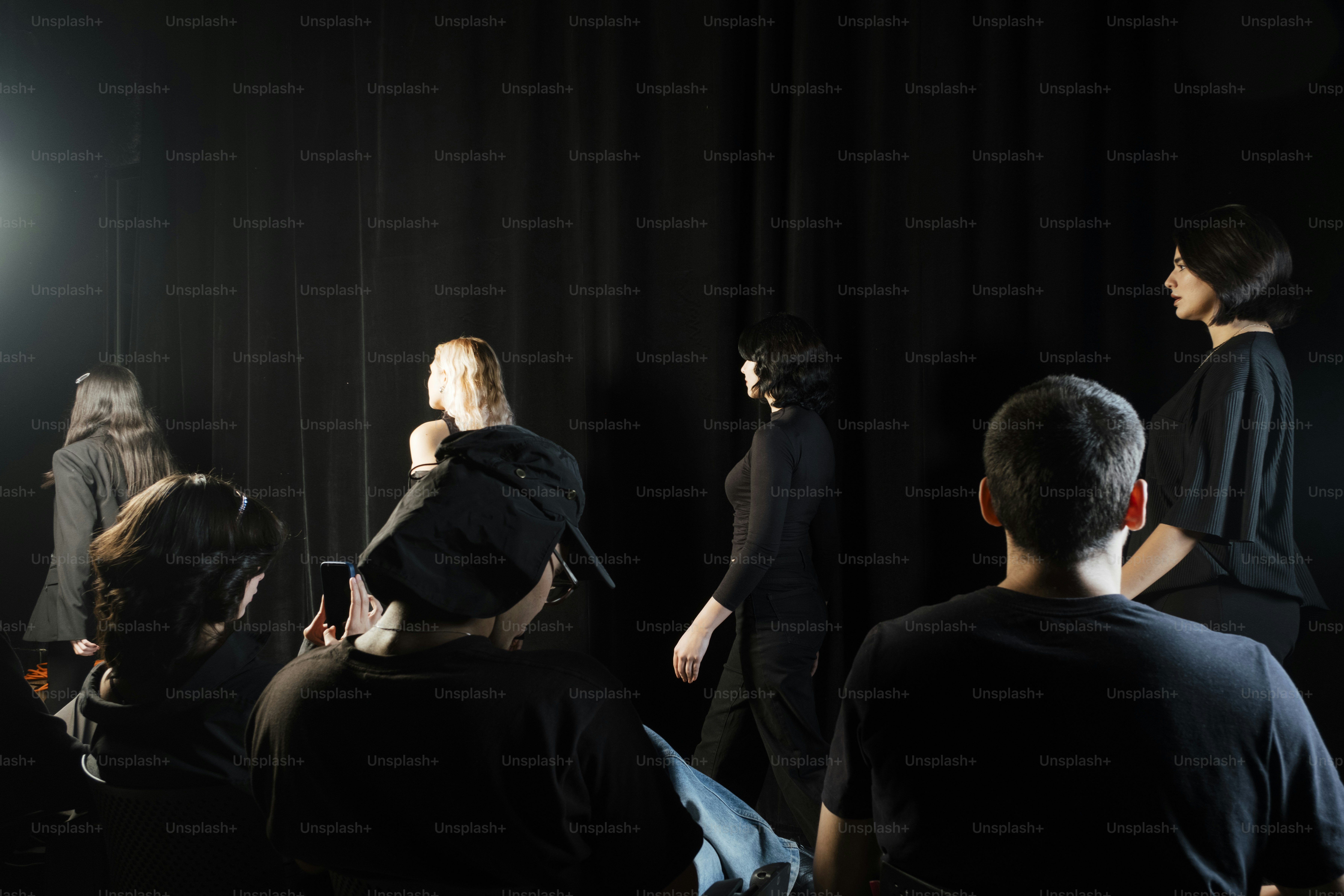 Des mannequins défilent sur un podium avec des spectateurs.