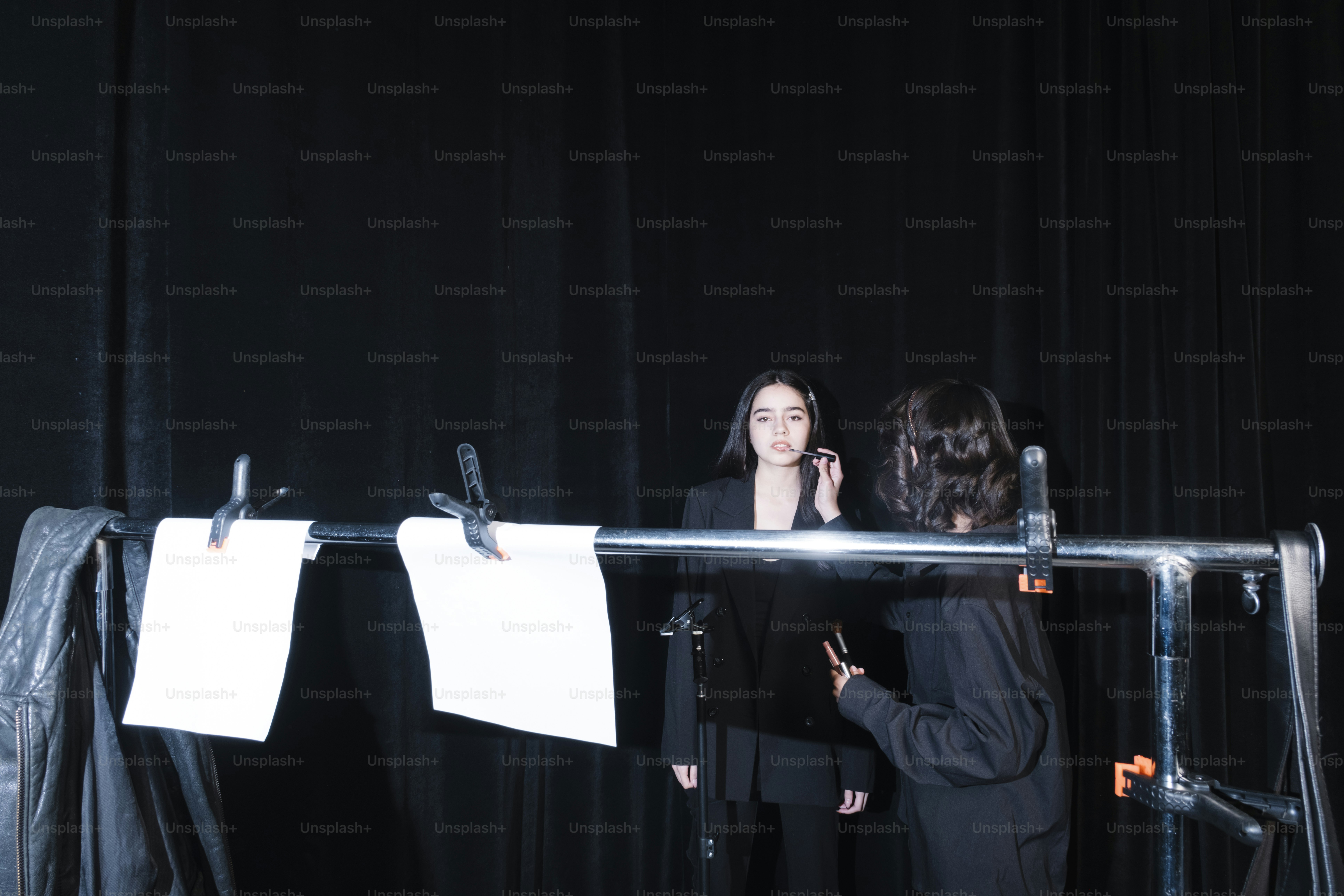 Two people stand behind a lighting setup.