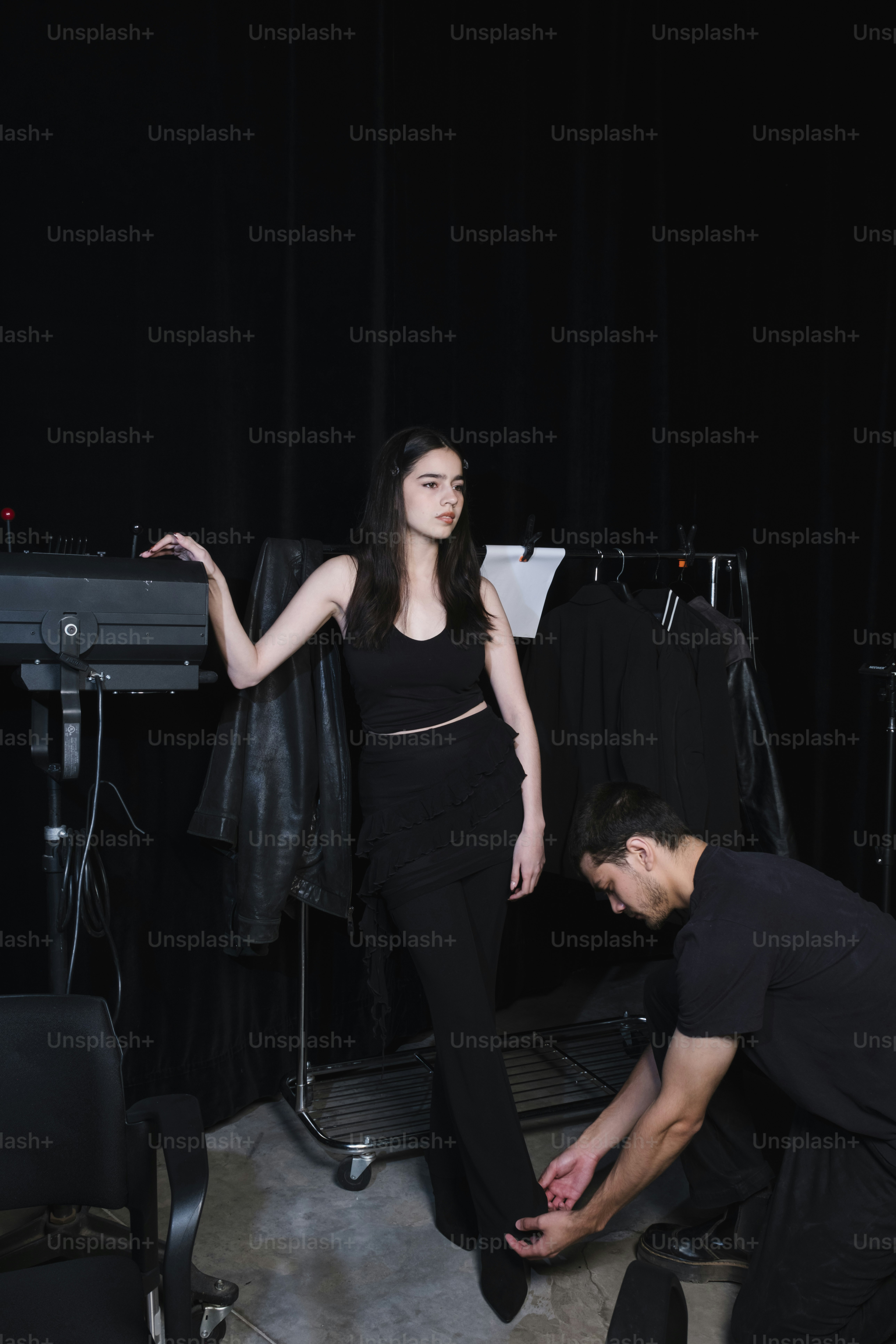 A model has her shoe adjusted backstage.
