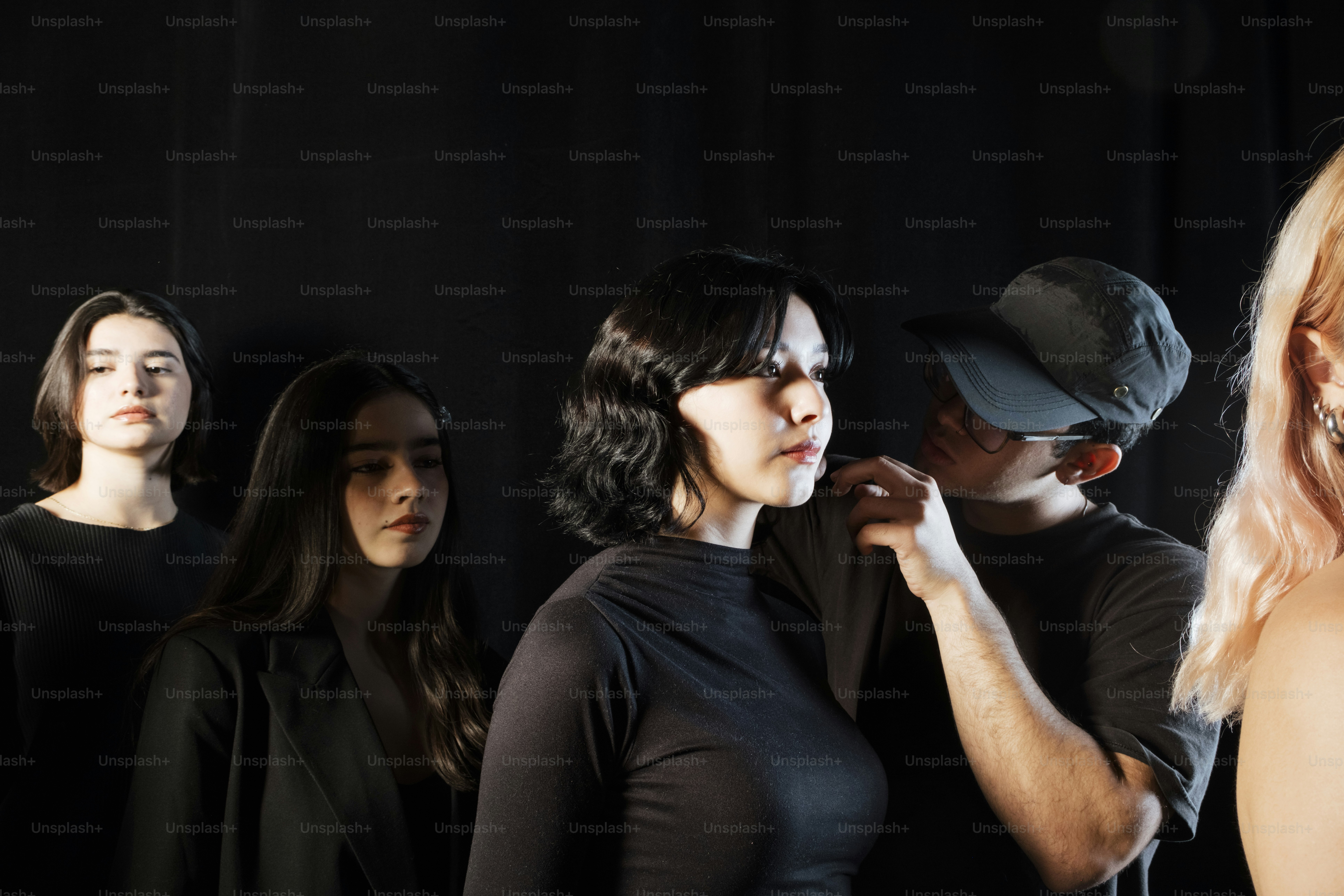 People stand together in front of a black backdrop.