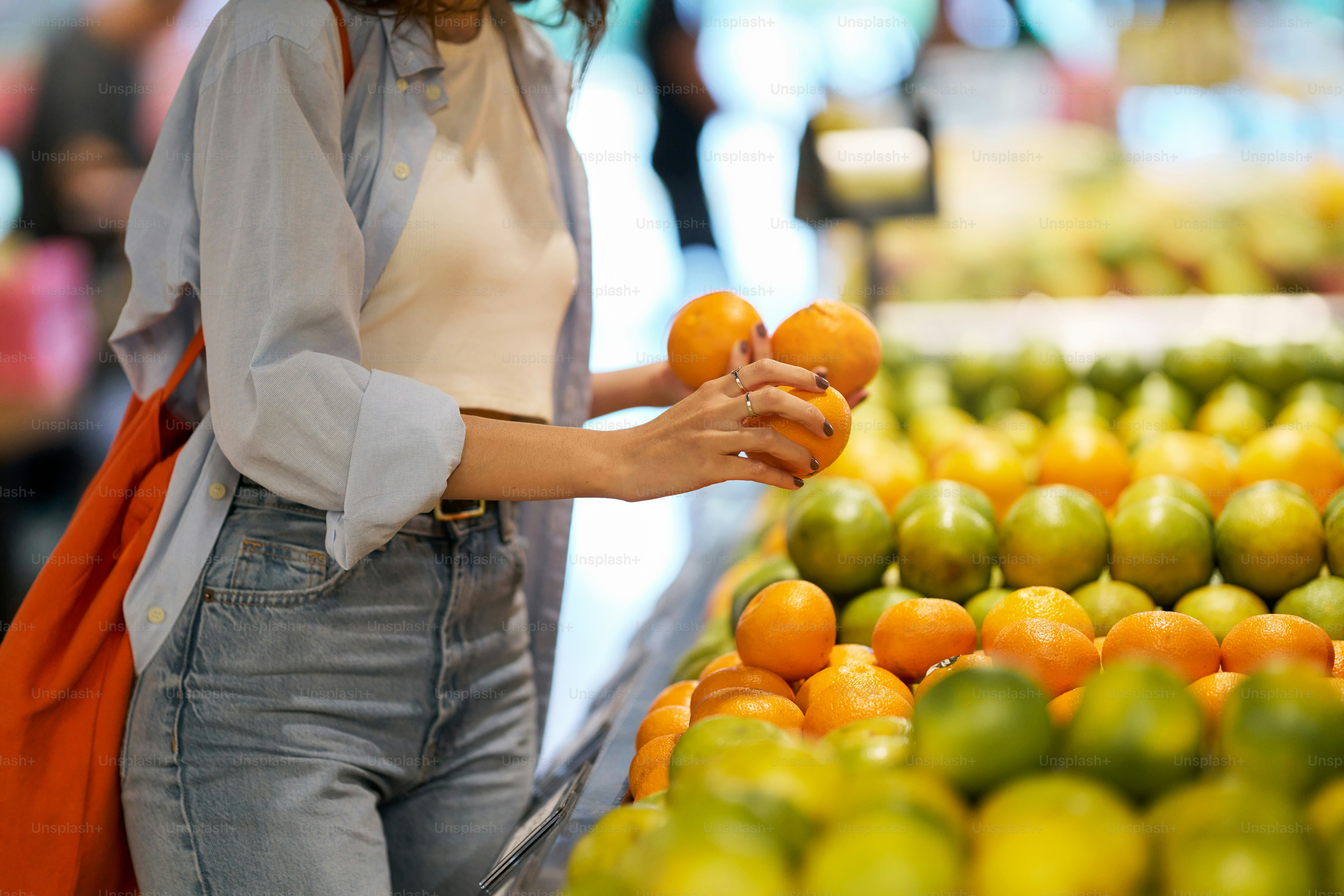 Woman picks oranges at a grocery store