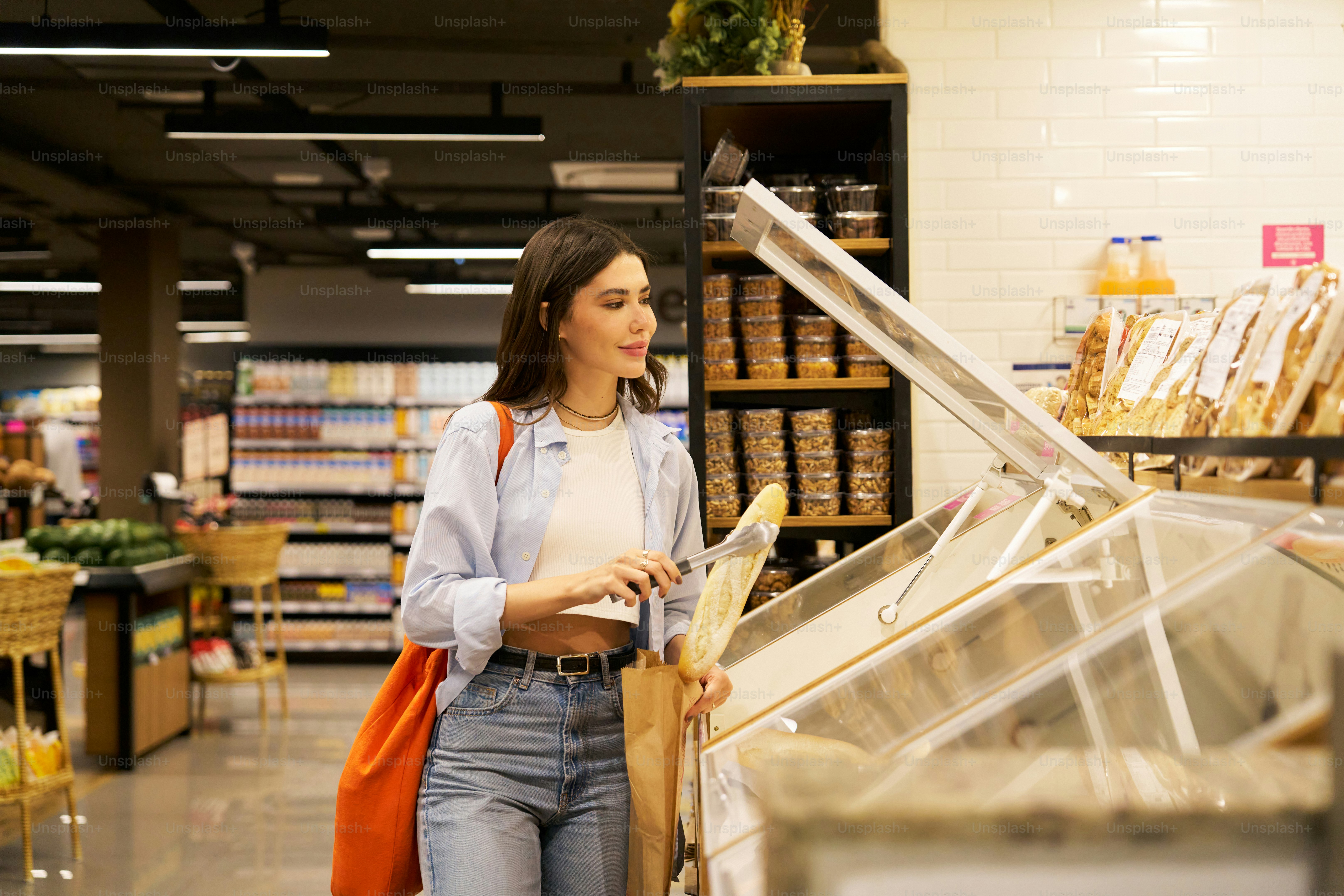 Woman shopping for bread in a grocery store.