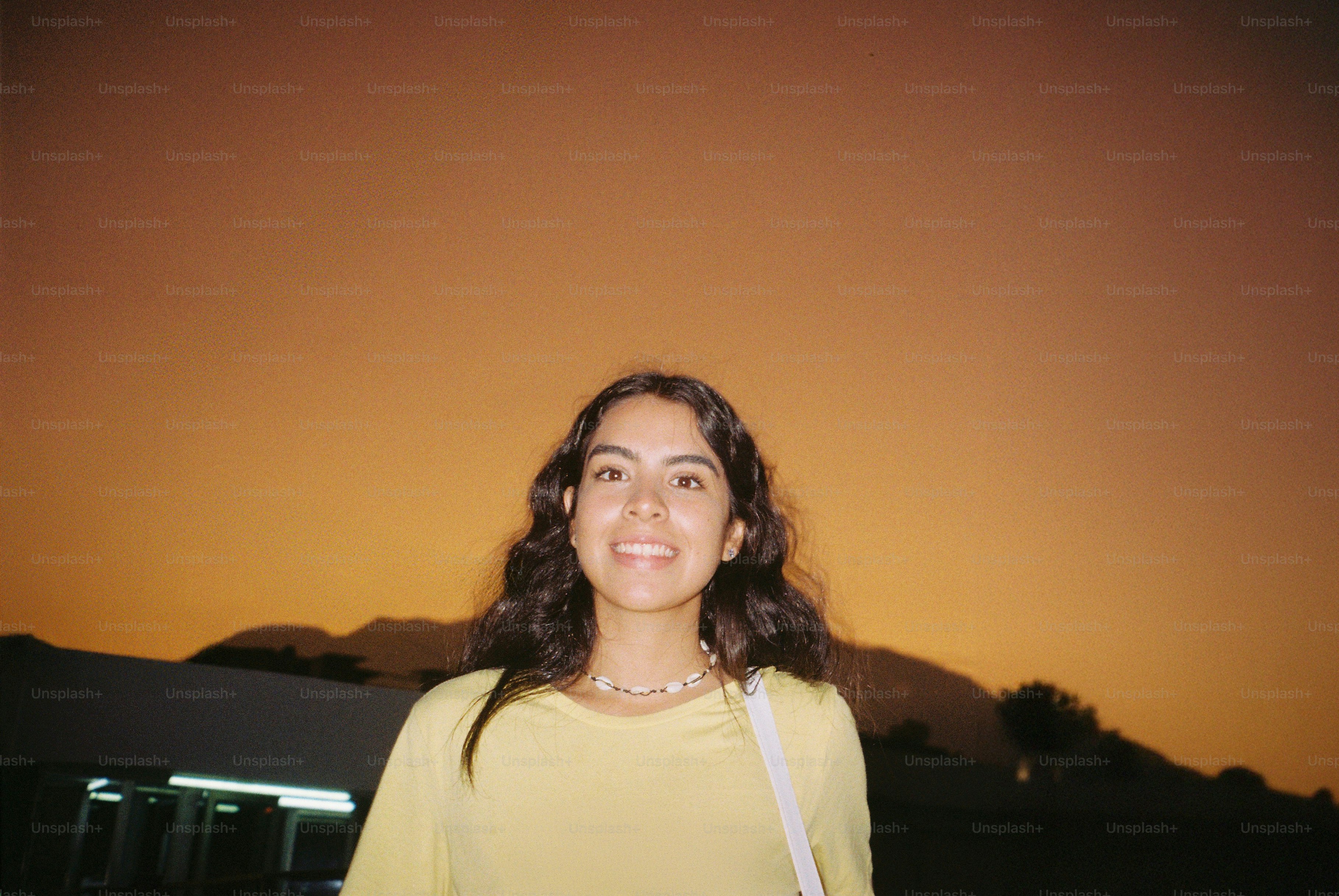 Young woman smiles during a sunset.