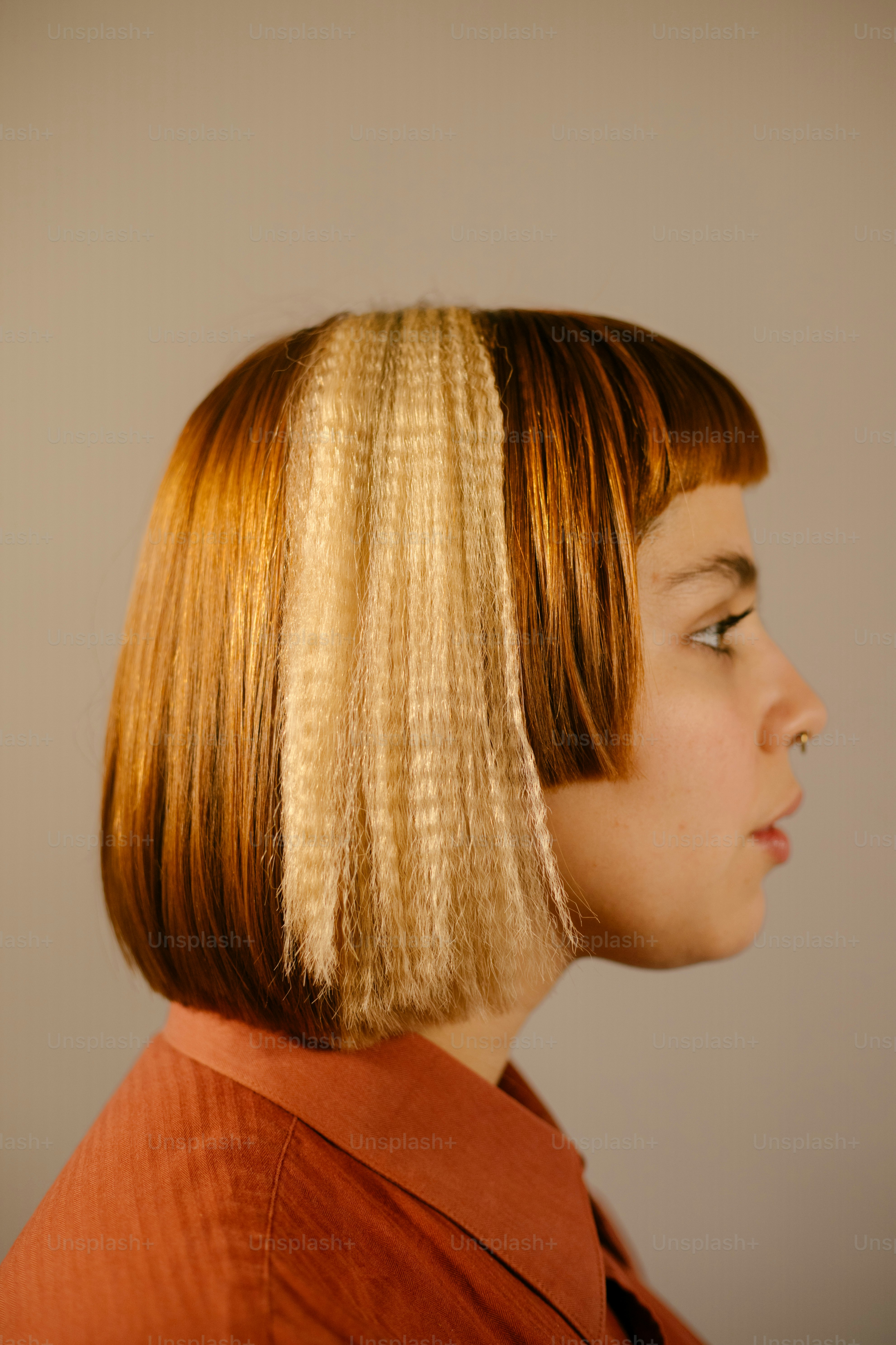 Les cheveux de la femme présentent une section blonde frisée.