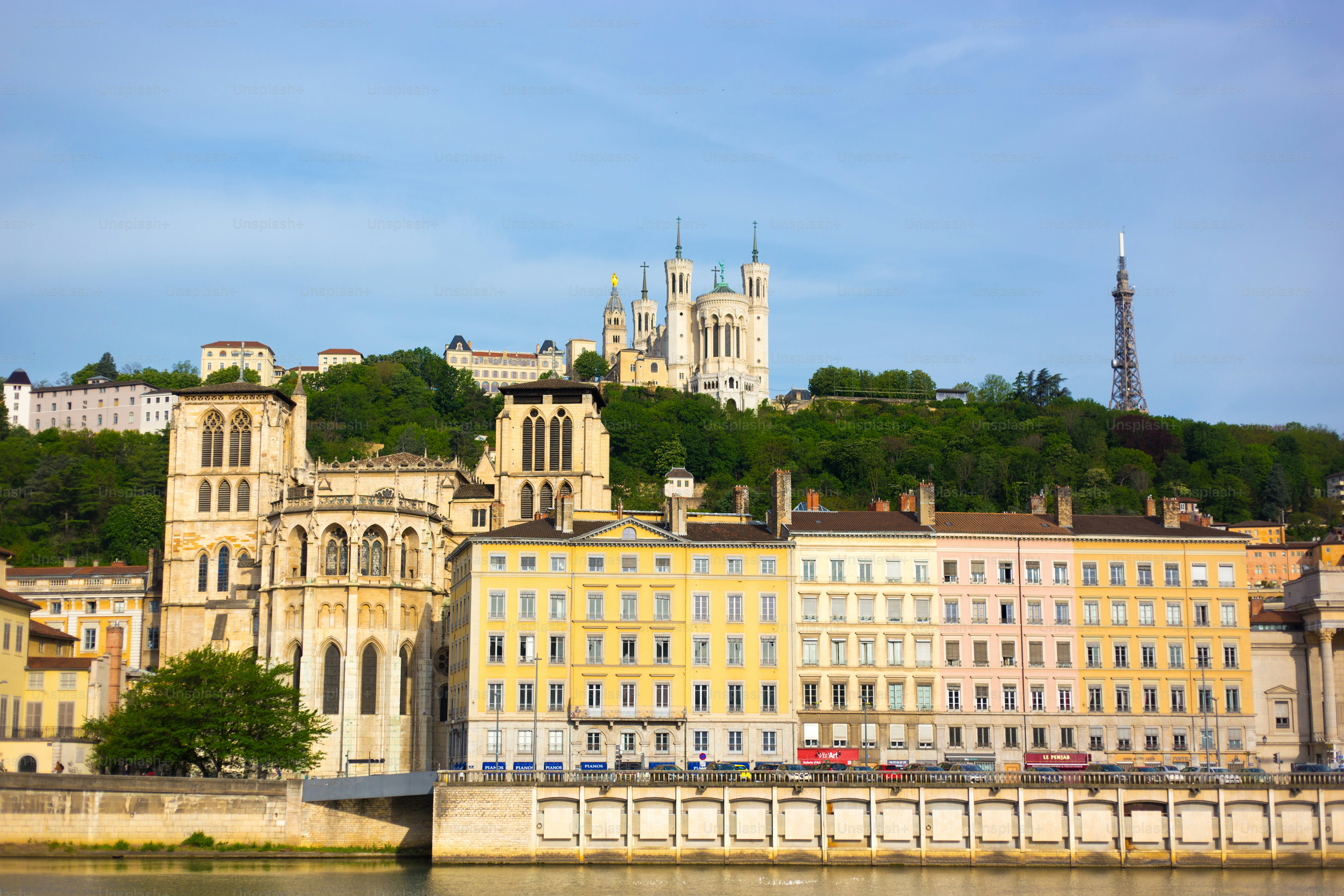 Lyon, Francia: Basílica de Notre-Dame de Fourvière bajo un cielo azul. Debajo de la basílica, en el río Saona, se encuentra la parte trasera de la Catedral de Lyon y el Vieux Lyon.