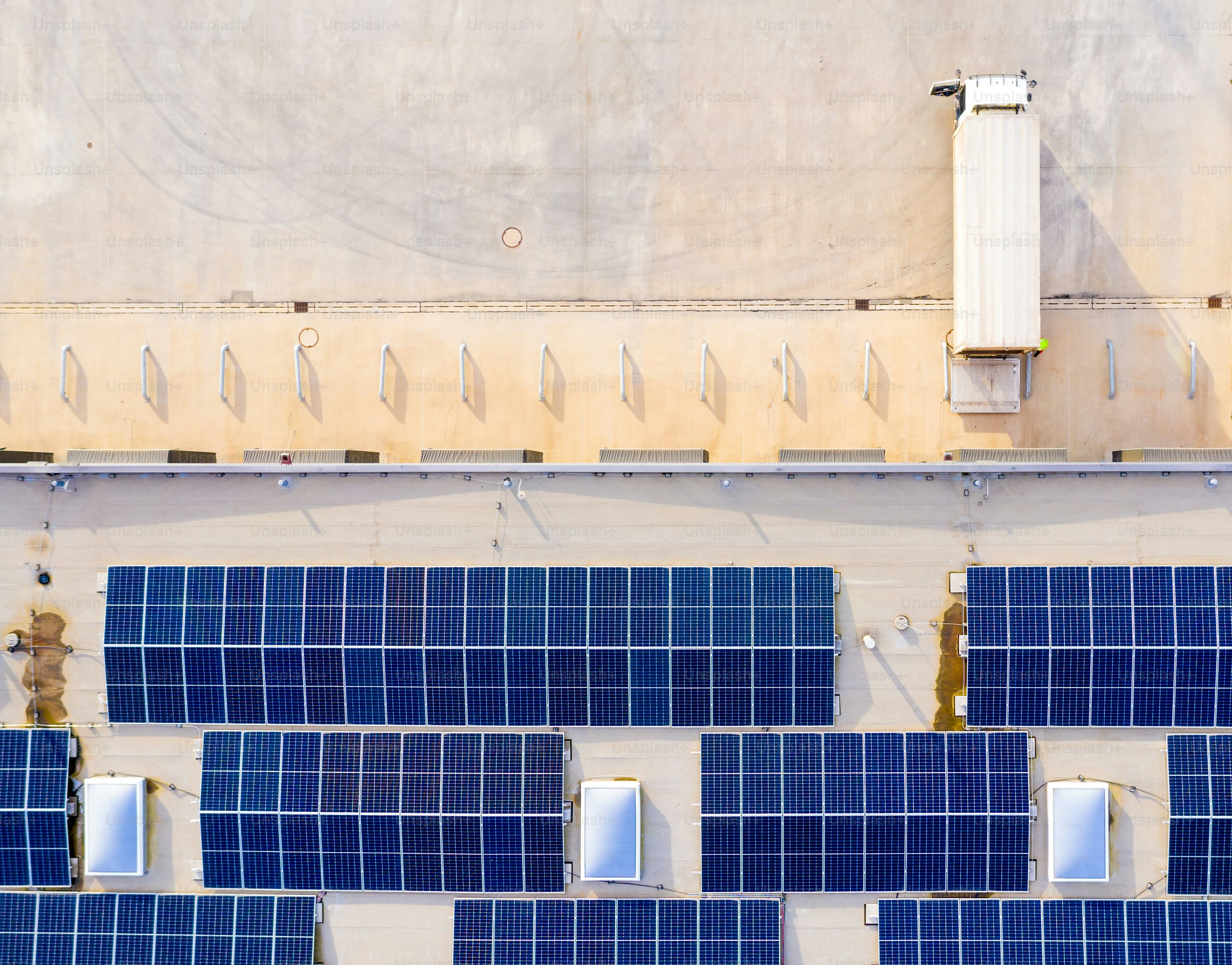 Industry with low carbon footprint. Industrial warehouses with solar panels on the roof. Technology park and factories from above.