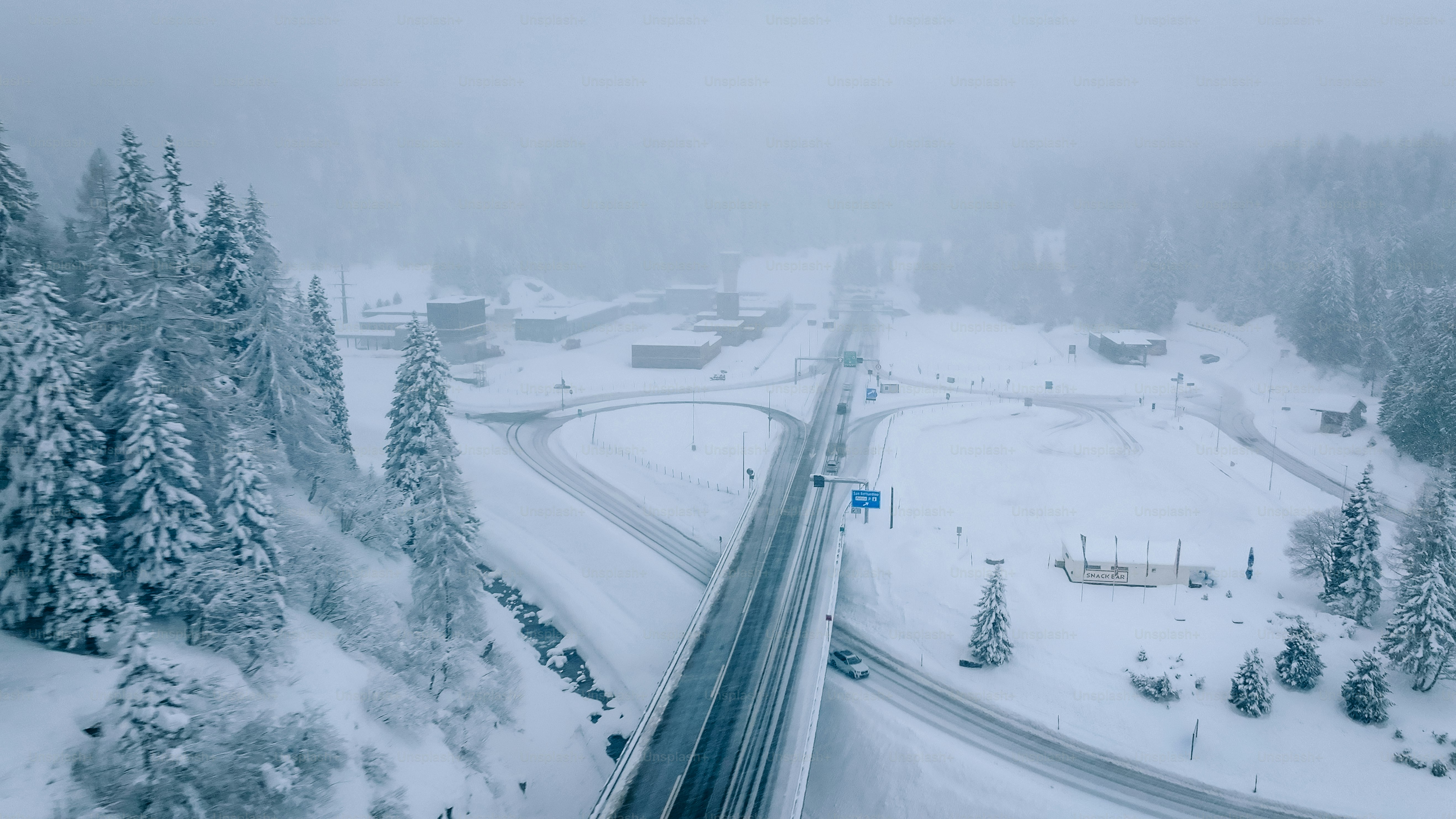 Aerial view of icy highway intersection in snowstorm, San Bernardino Pass, Ticino