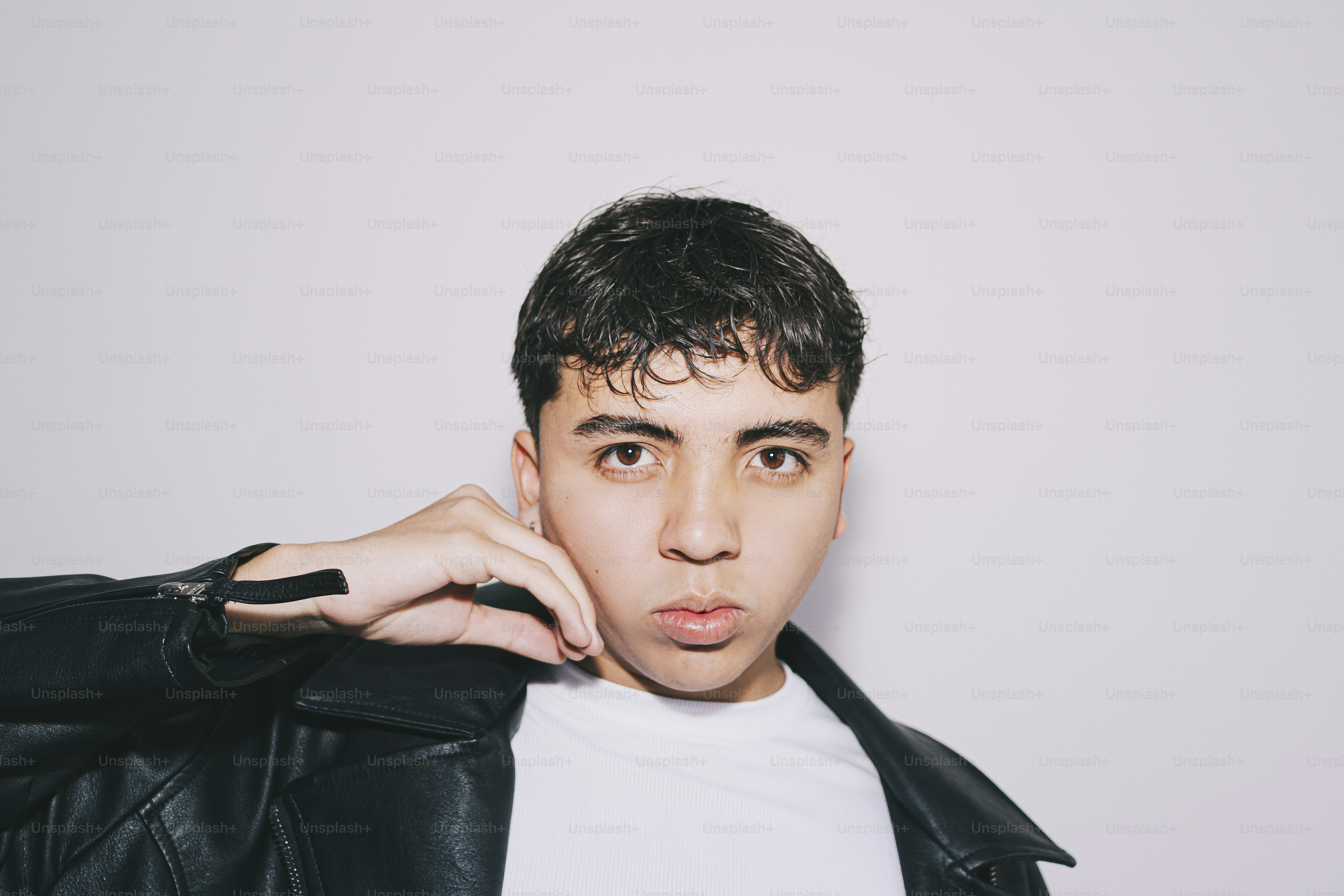 Young man poses in a leather jacket.