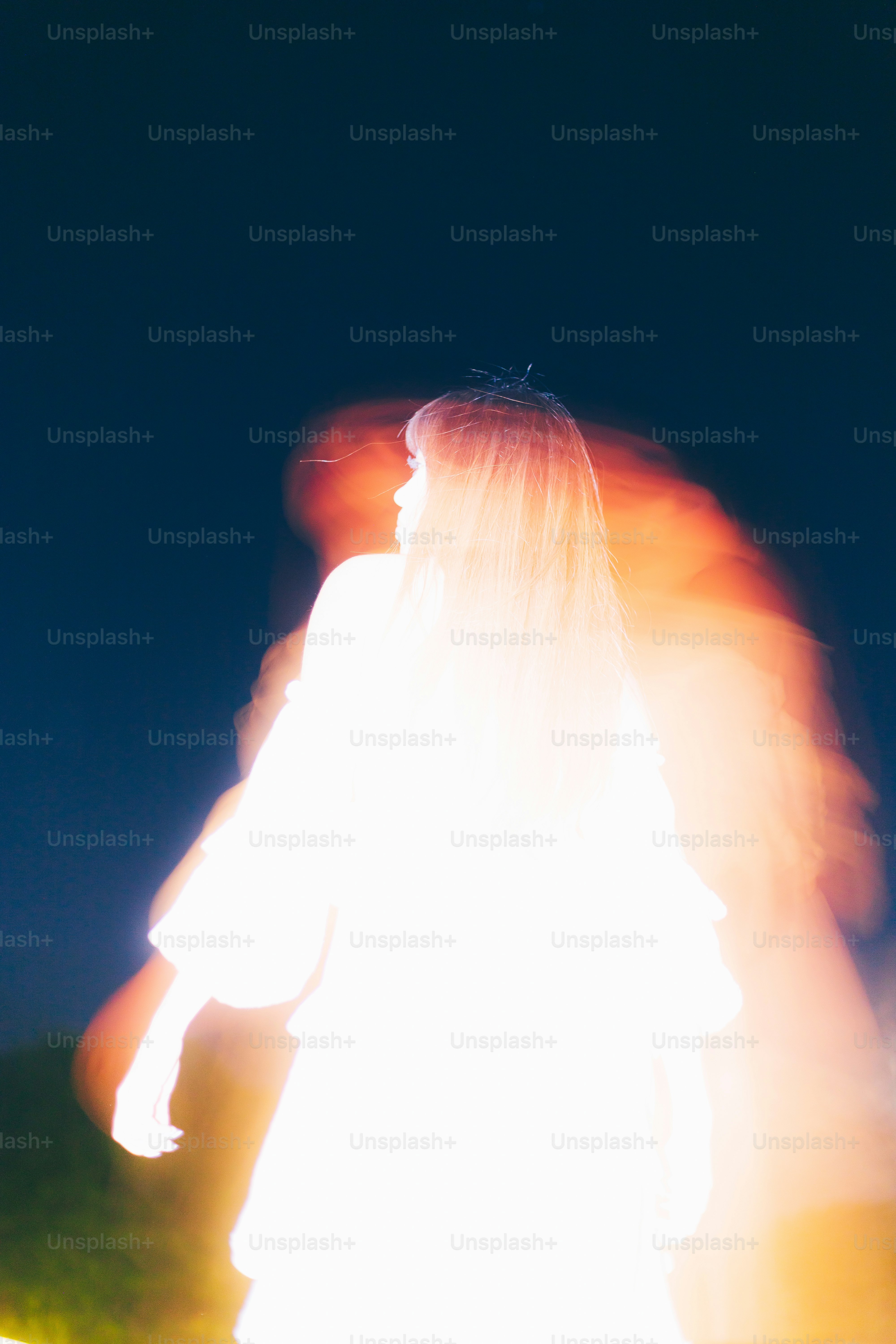 Eine leuchtende Frau, die sich als Silhouette gegen den Nachthimmel abzeichnete.