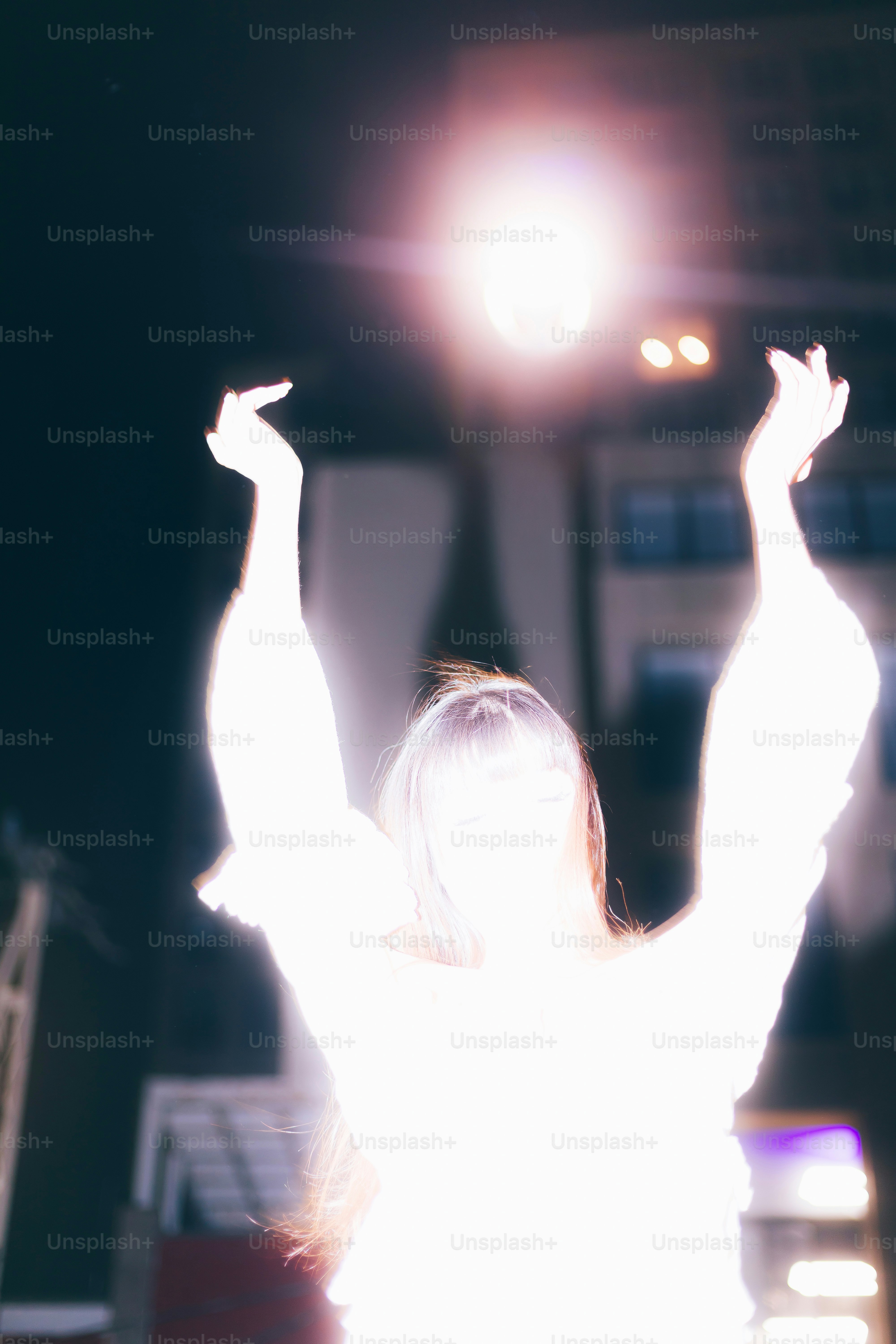 A glowing person reaches upward towards light.