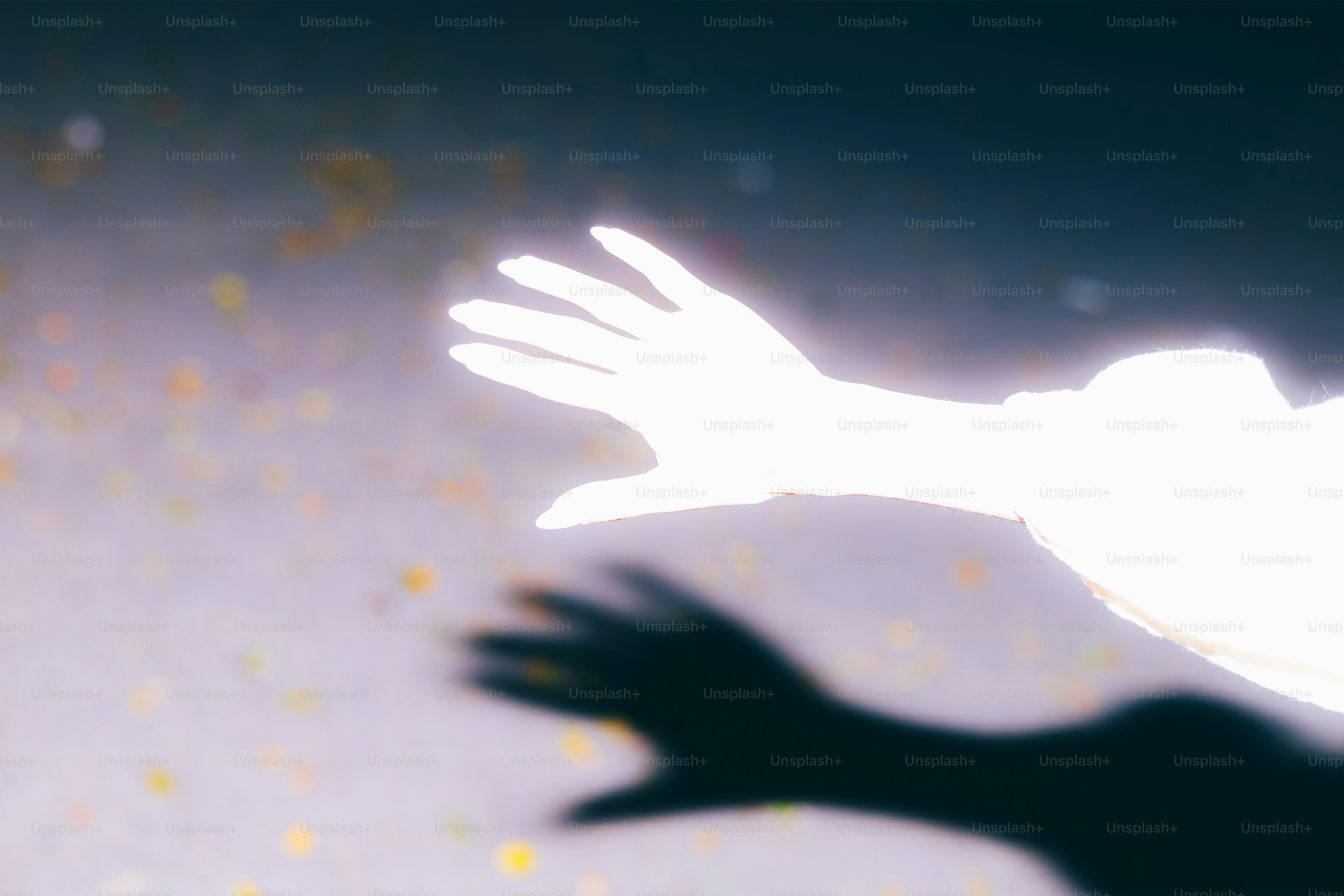 Eine glühende Hand streckt sich in die Dunkelheit aus.