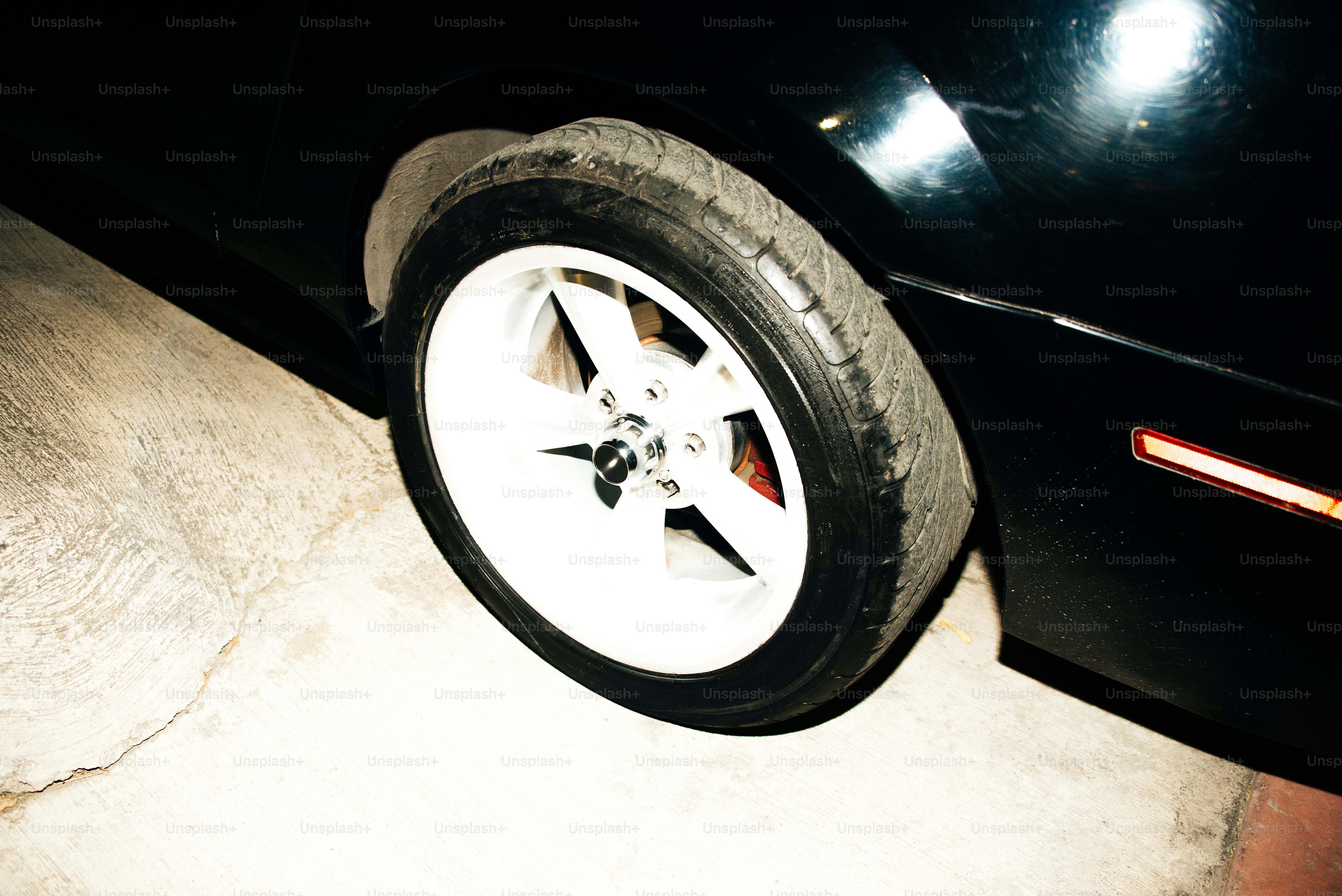 Um carro preto com uma roda branca.