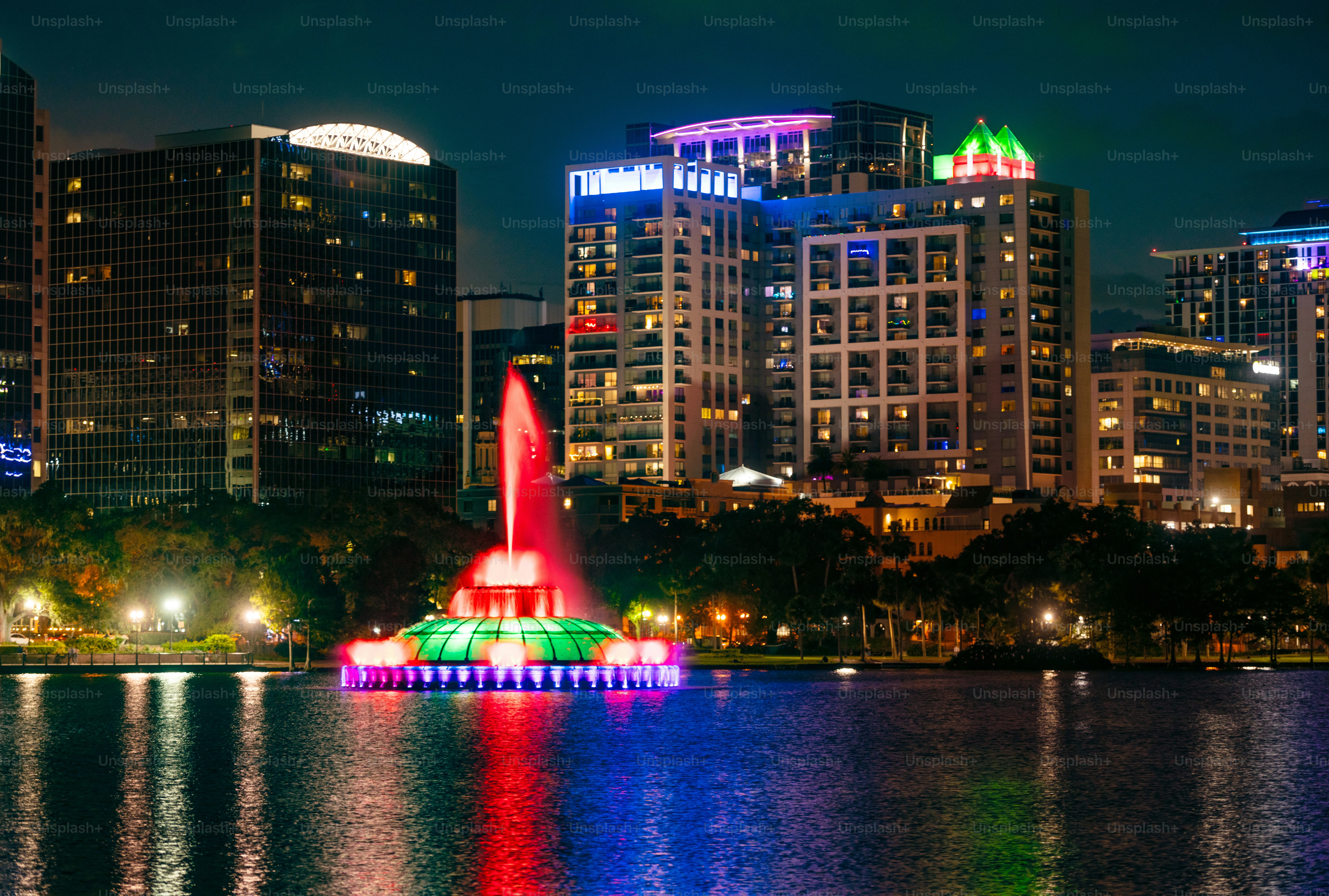 This is a photograph of Lake Eola’s fountain in downtown Orlando, Florida illuminated at night.