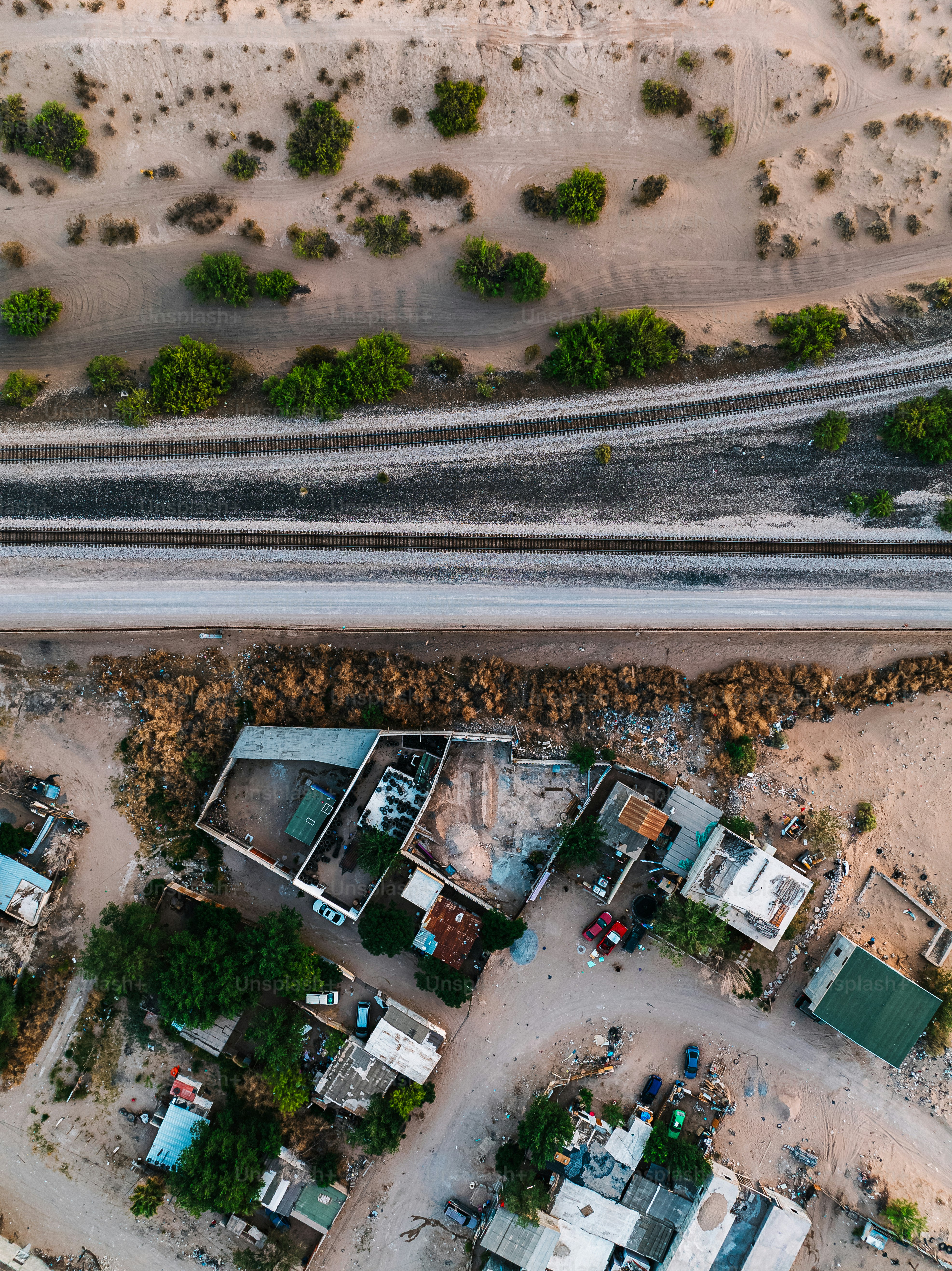 Aerial View of the U.S. Southern Border Wall Fence, (“El Muro Fronterizo,”) separating El Paso and Ciudad Juárez, Mexico in Springtime. The railroad track supports trade between Mexico and the USA. 

Photo taken in Mexico