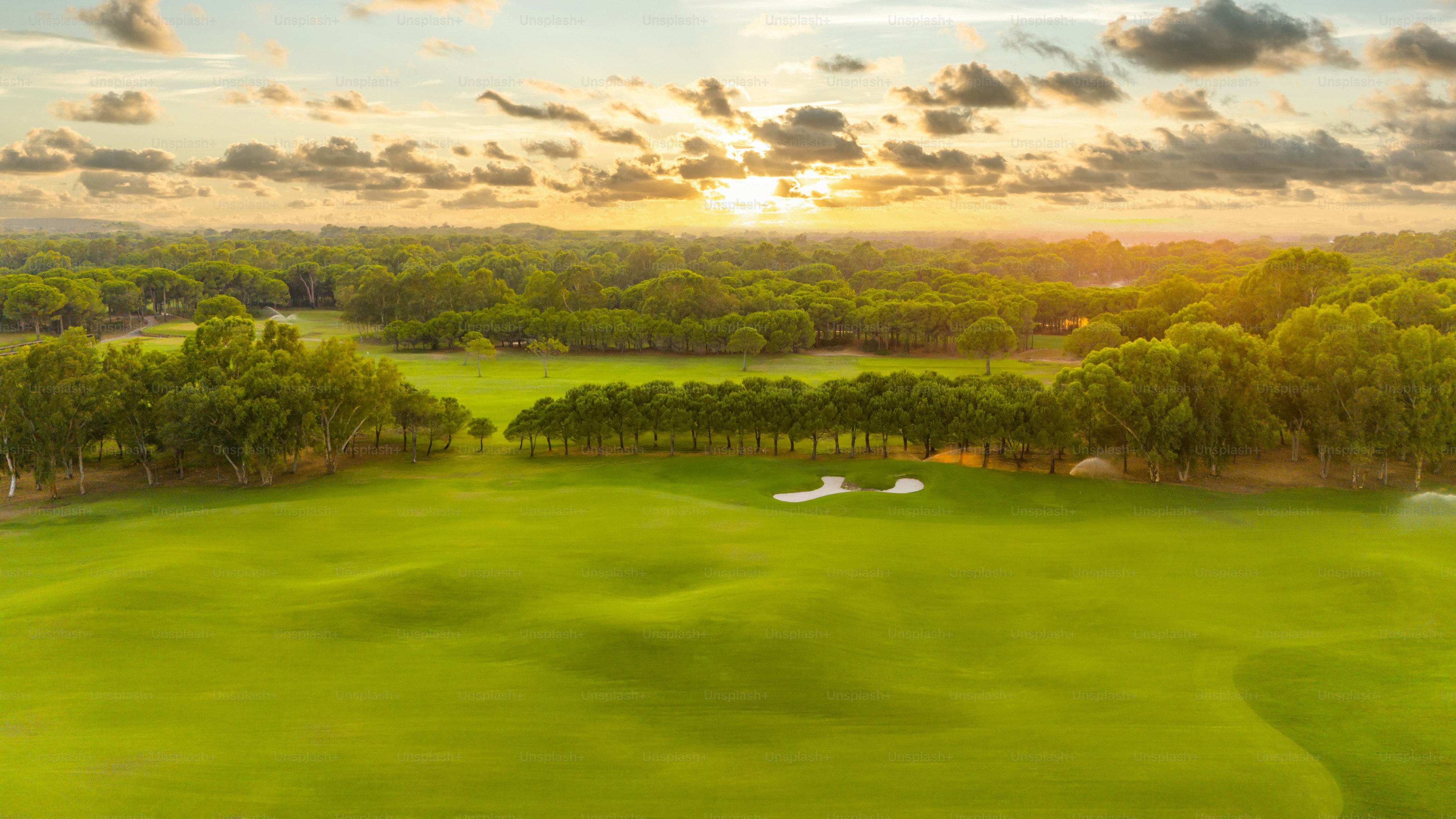 Vue par drone du terrain de golf au coucher du soleil avec un ciel magnifique