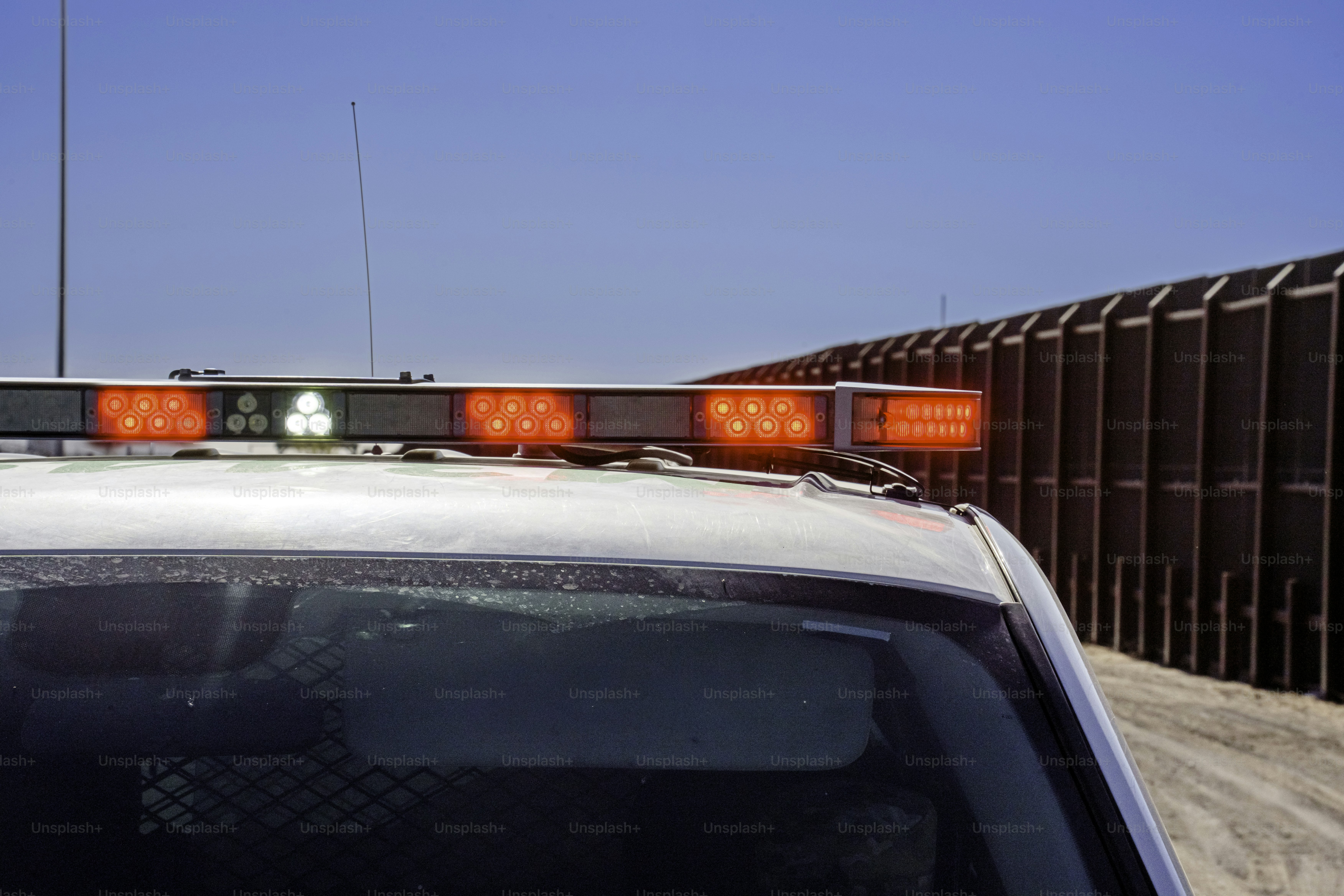 Border Patrol Vehicle with Police Lights On Sitting in Front of Border Barrier Wall at Santa Teresa Crossing Into Mexico