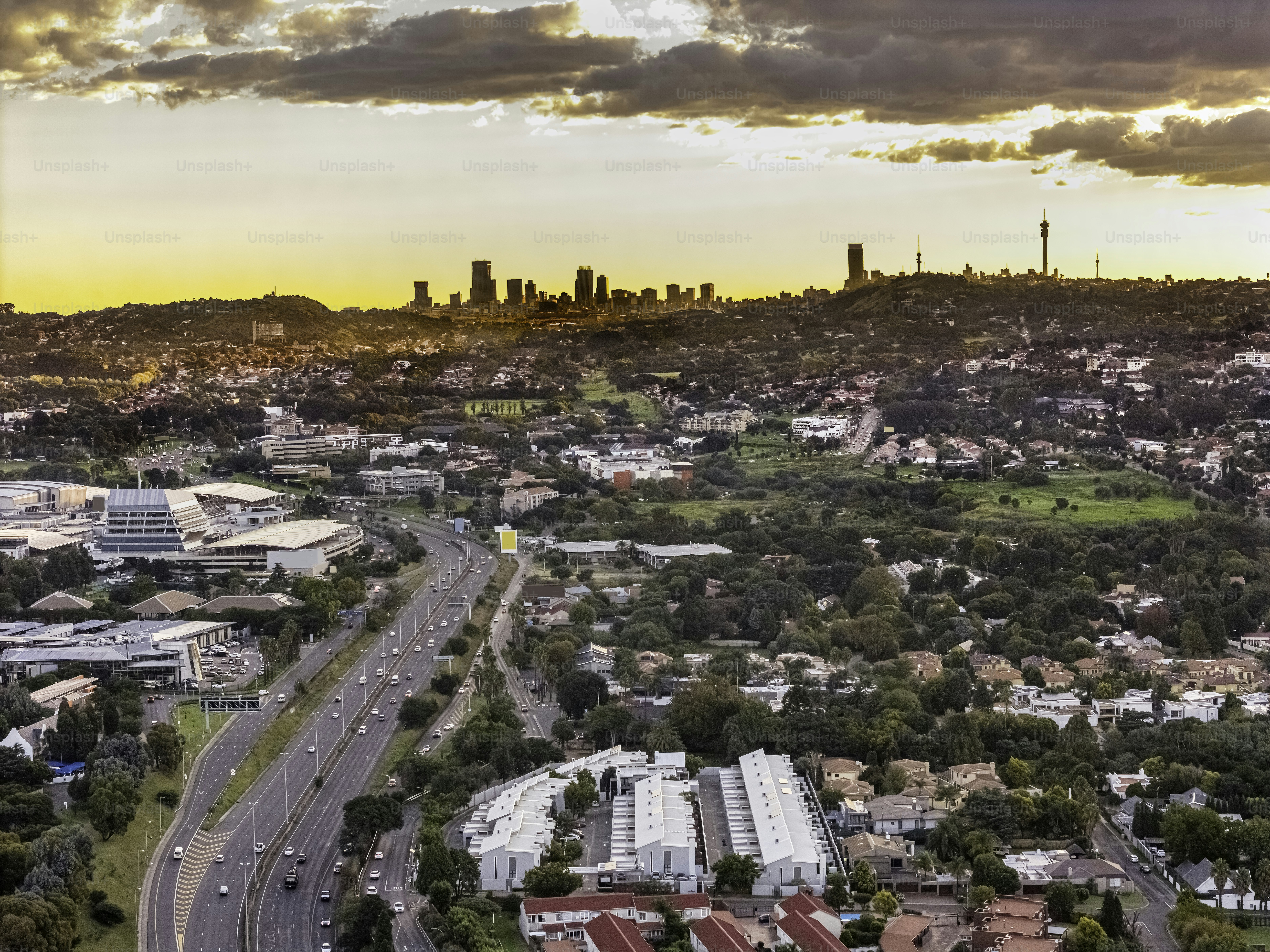 Johannesburg cityscape silhouette with the iconic Ponte apartments and communications tower and highway from the east leading into the city with Eastgate Shopping Centre mall on the left.