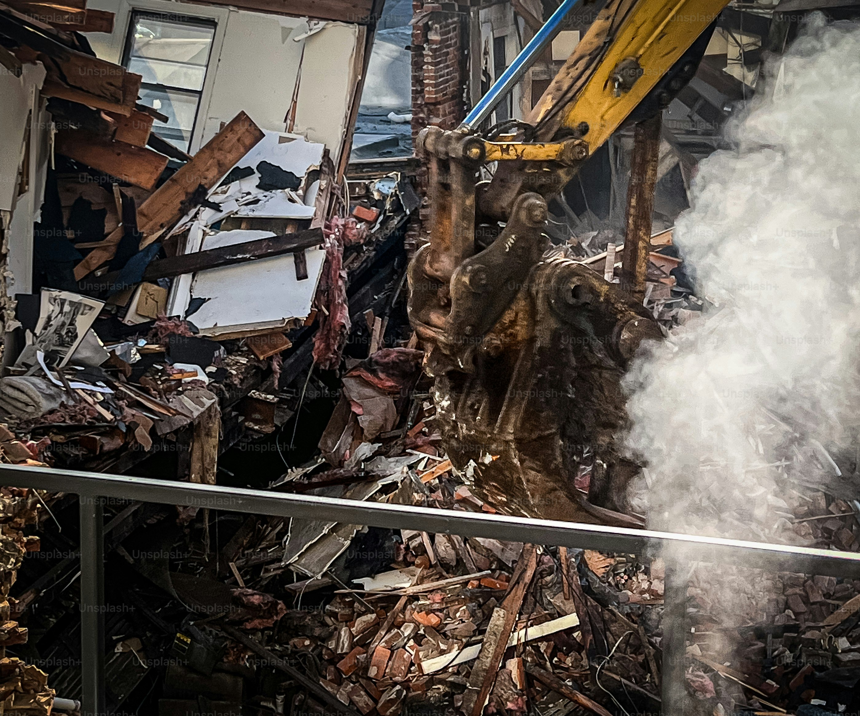 View from a window of a construction site destroying an old building, with bricks and all furniture inside with a huge crane claw