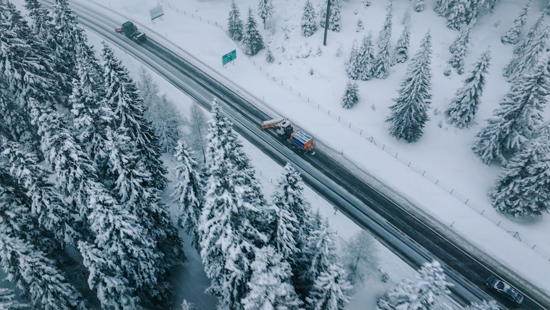Aerial view of plow truck clearing road on mountain highway during snowstorm, photo 2