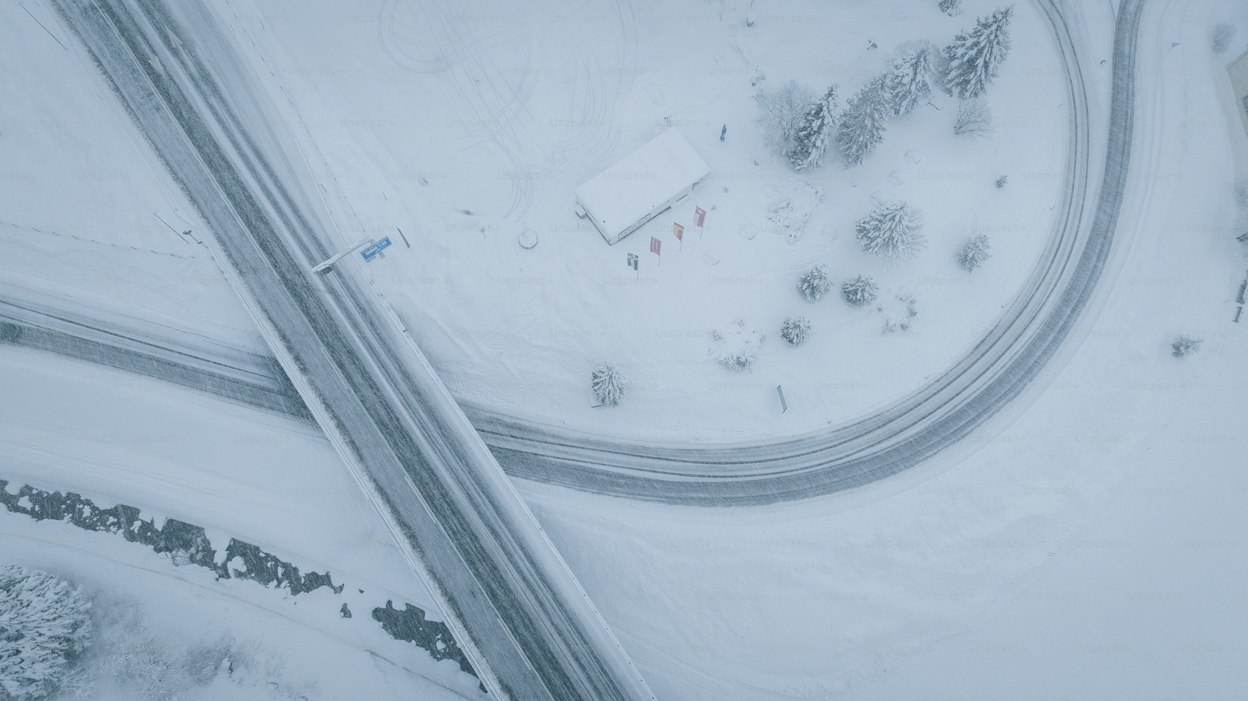 Aerial view of icy highway intersection in snowstorm, San Bernardino Pass, Ticino