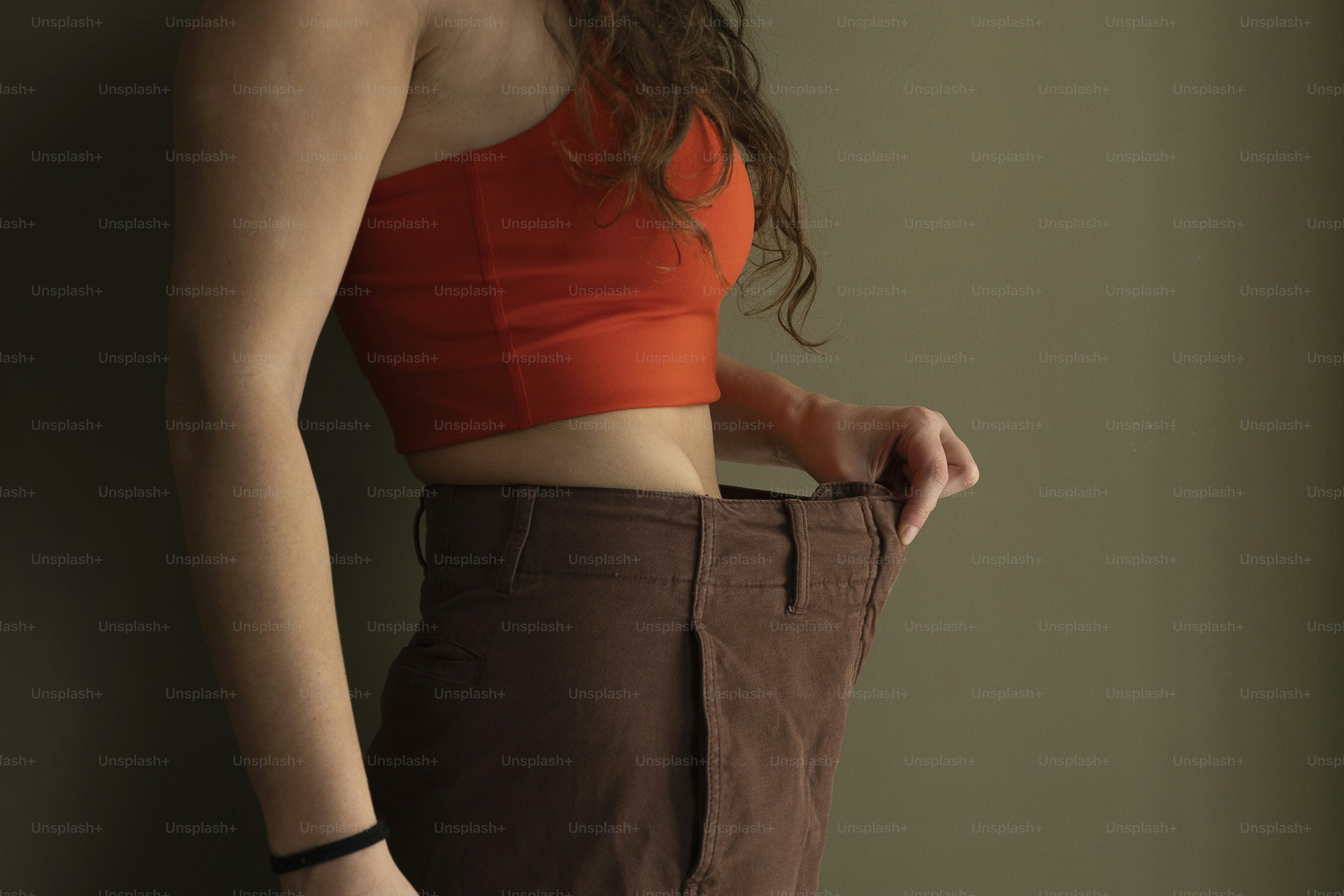 Woman shows off weight loss in her pants.