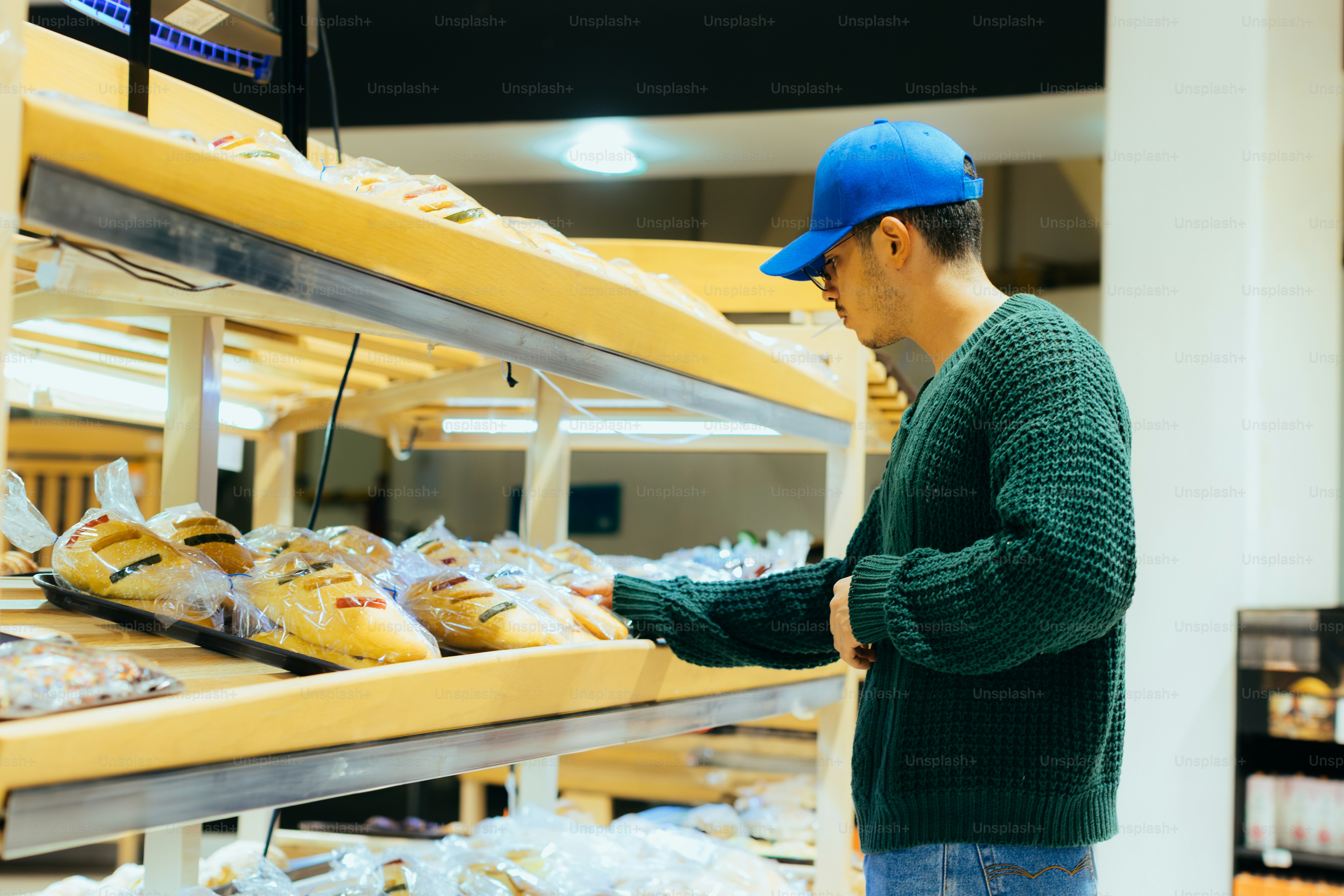 Man is shopping for bread in a bakery.
