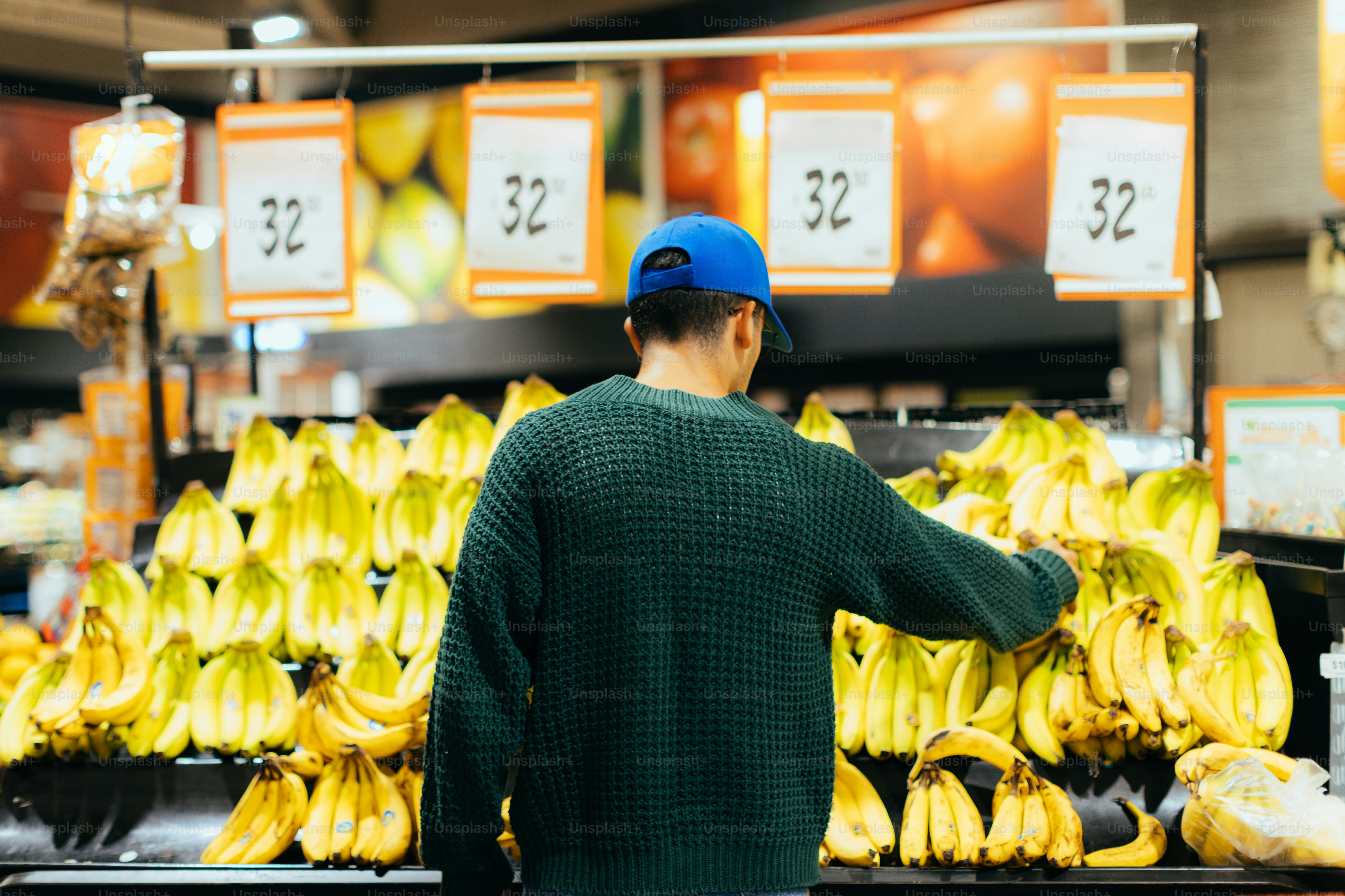 A person shops for bananas in a grocery store.