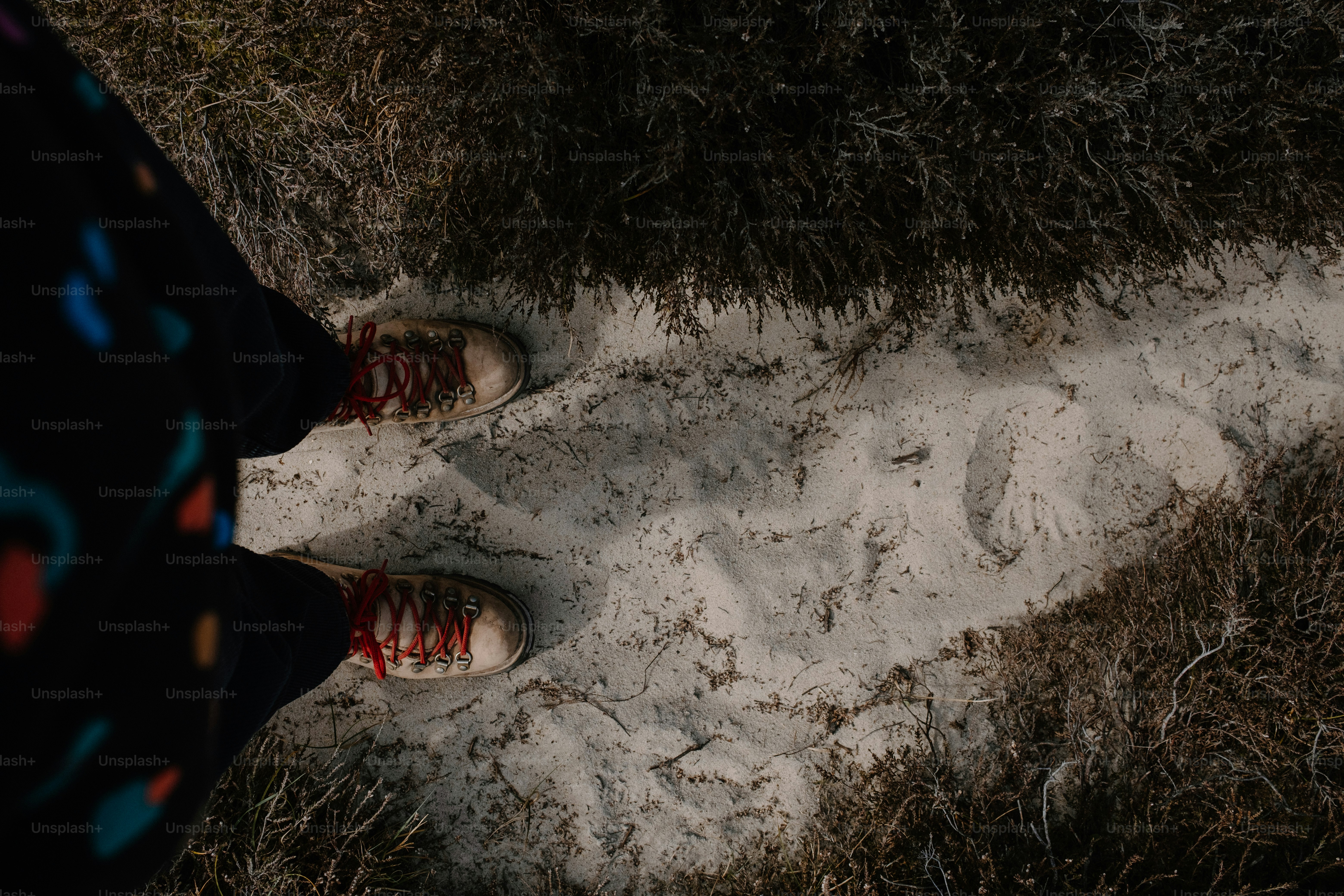 Les pieds se tiennent sur un chemin enneigé, révélant des empreintes de pas.