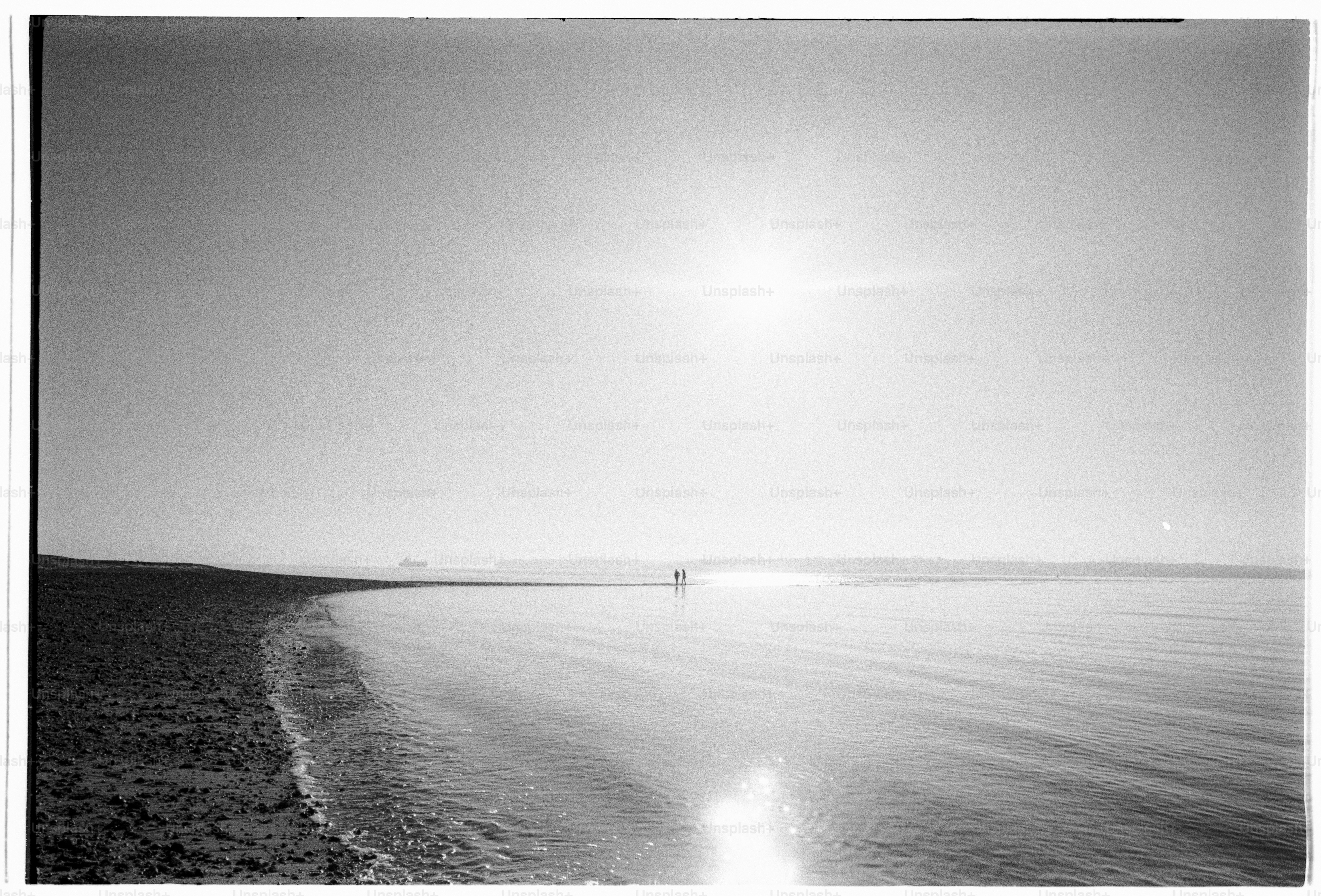 A beach at sunset in black and white.