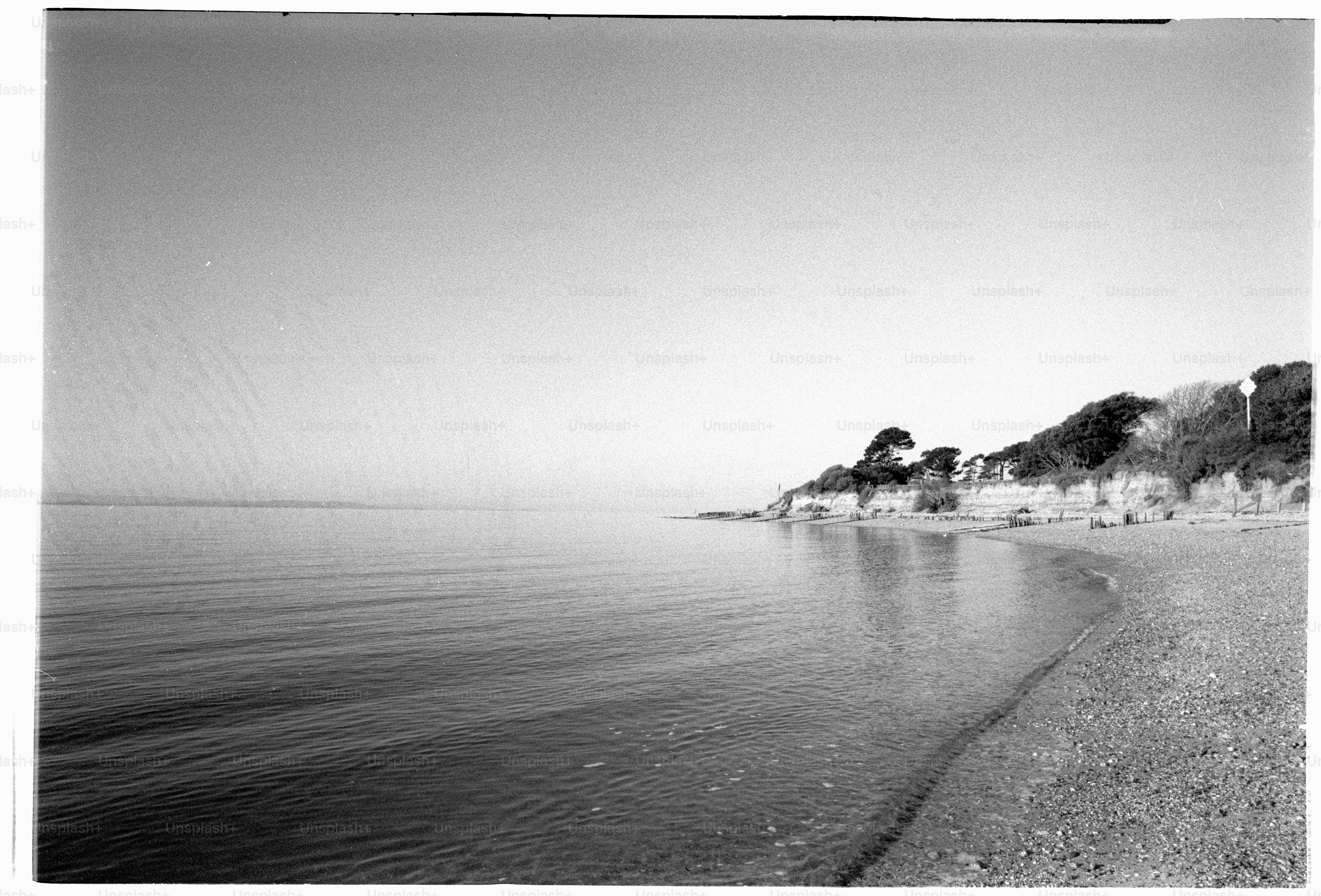 Quiet beach with gentle waves and a cliff.