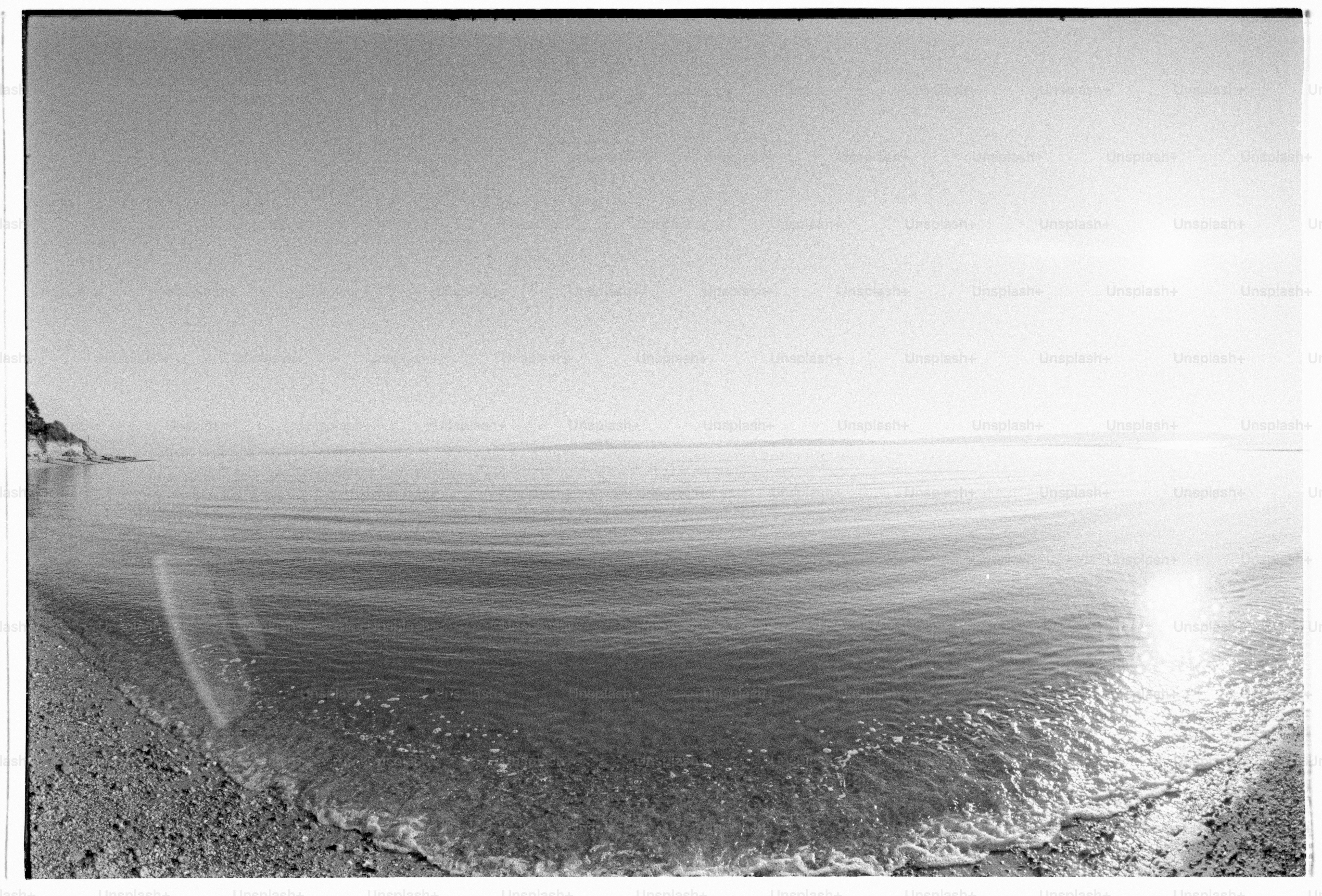 Calm beach scene with bright, shining sun.