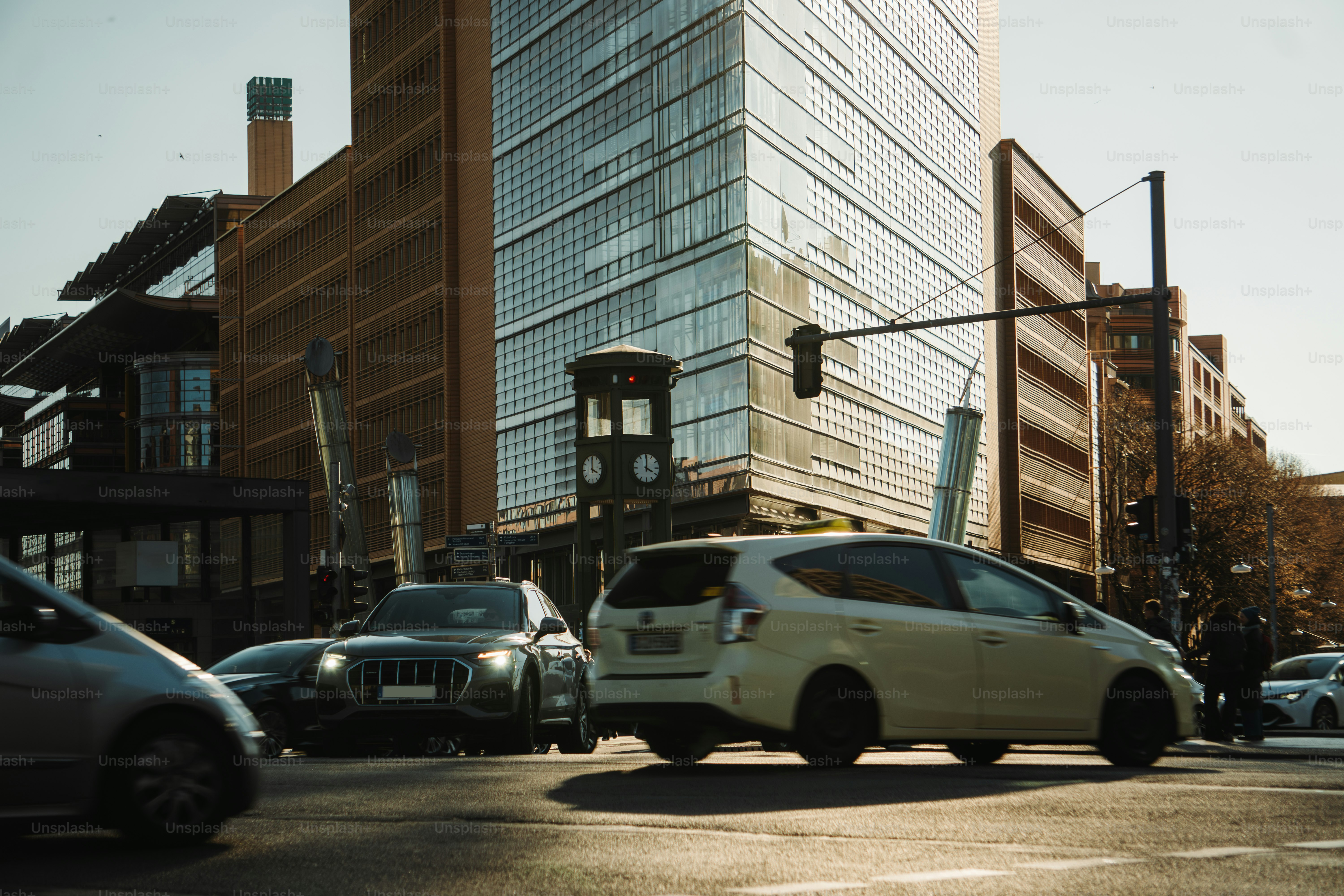 Cars drive through a city intersection.