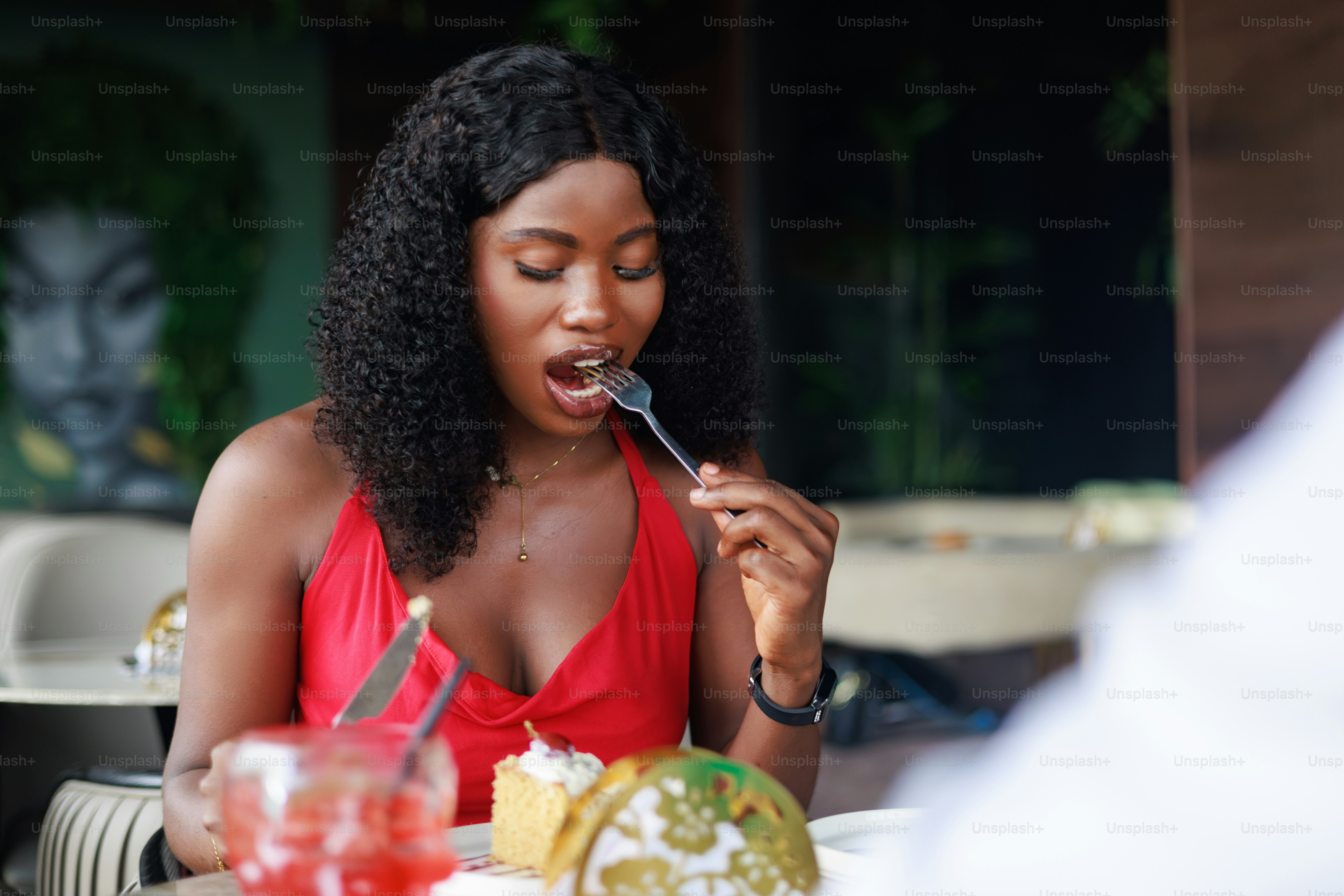 Woman enjoys a bite of food at a restaurant.