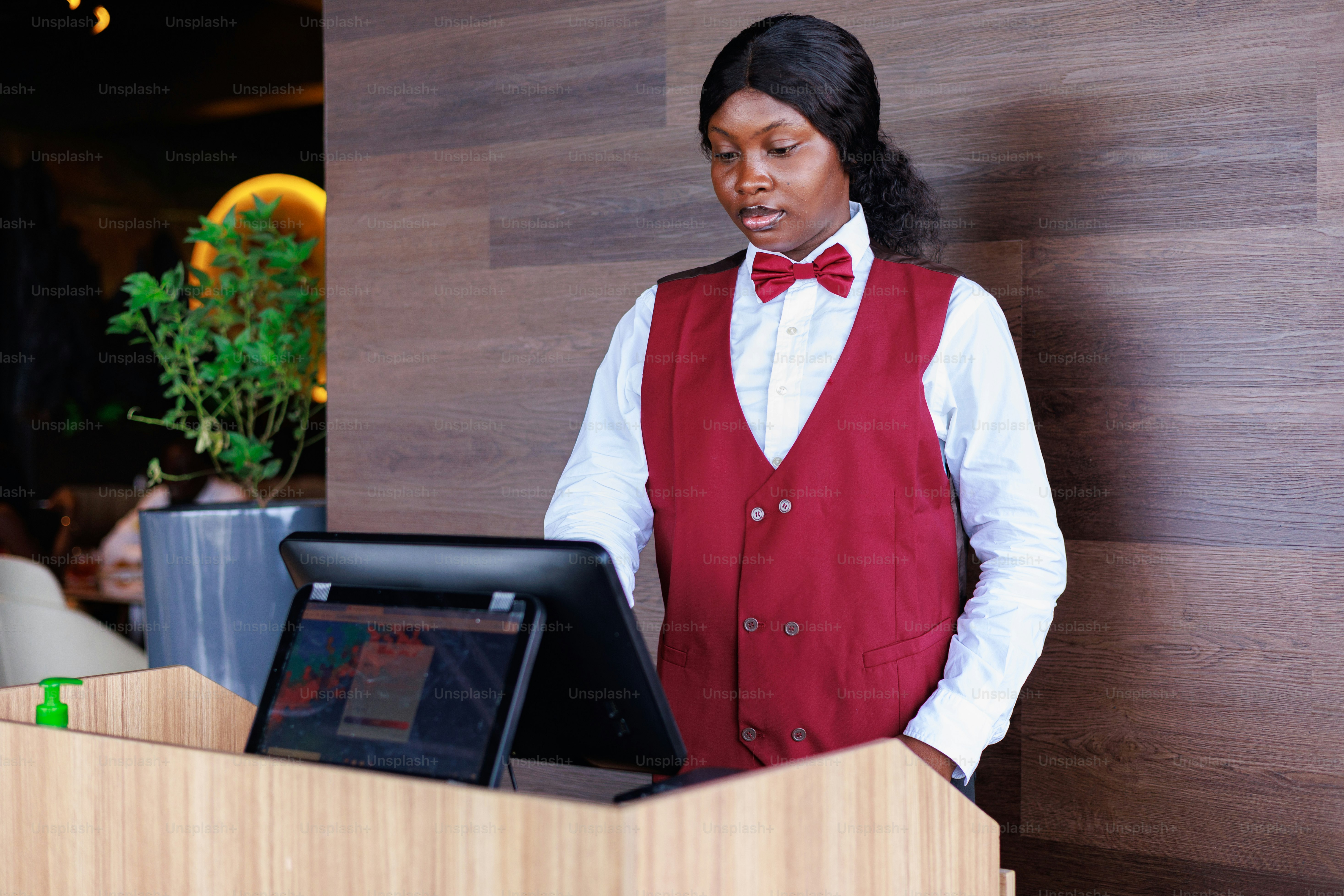 A server stands at a restaurant's point of sale.