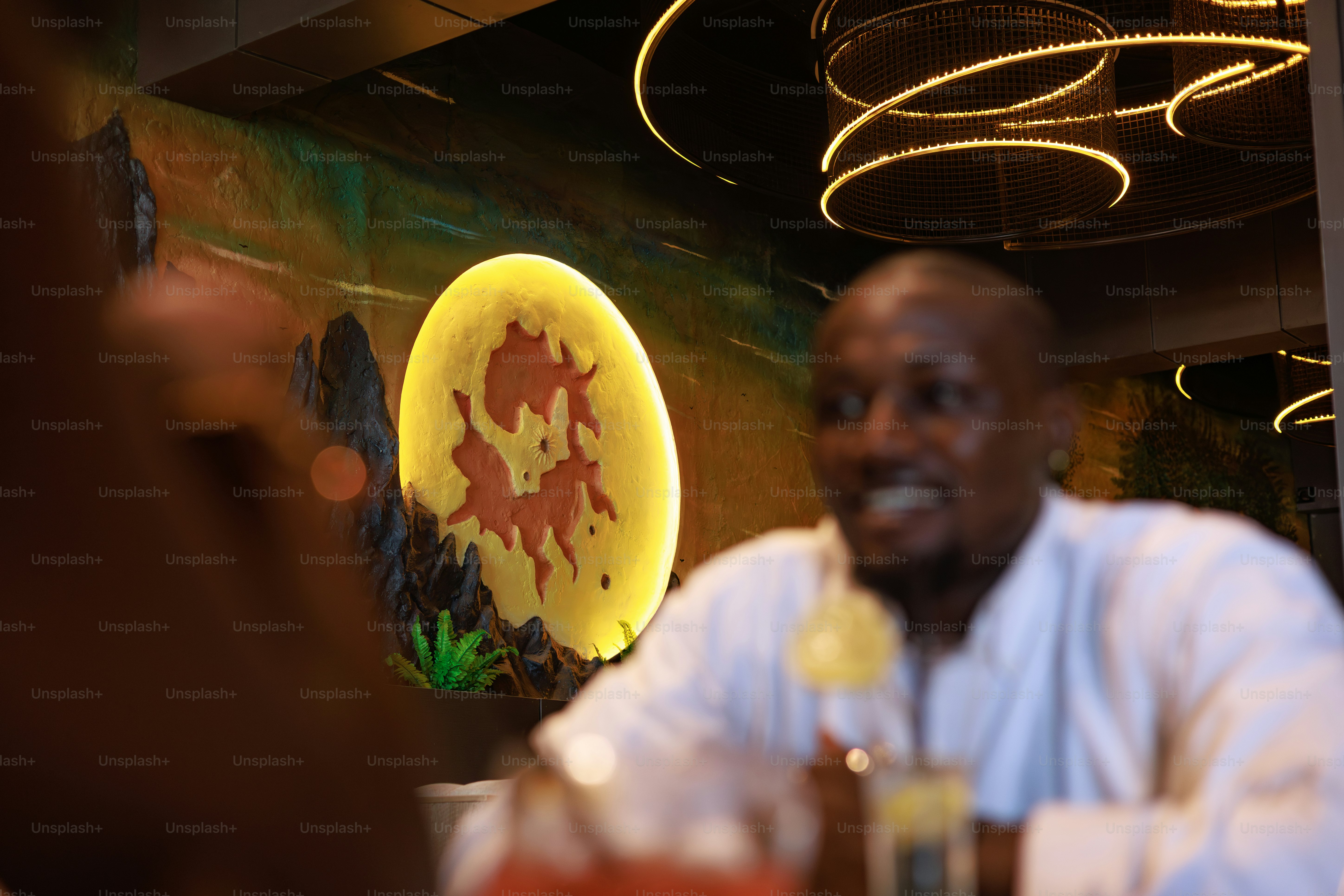 A man smiles with a drink in a bar.