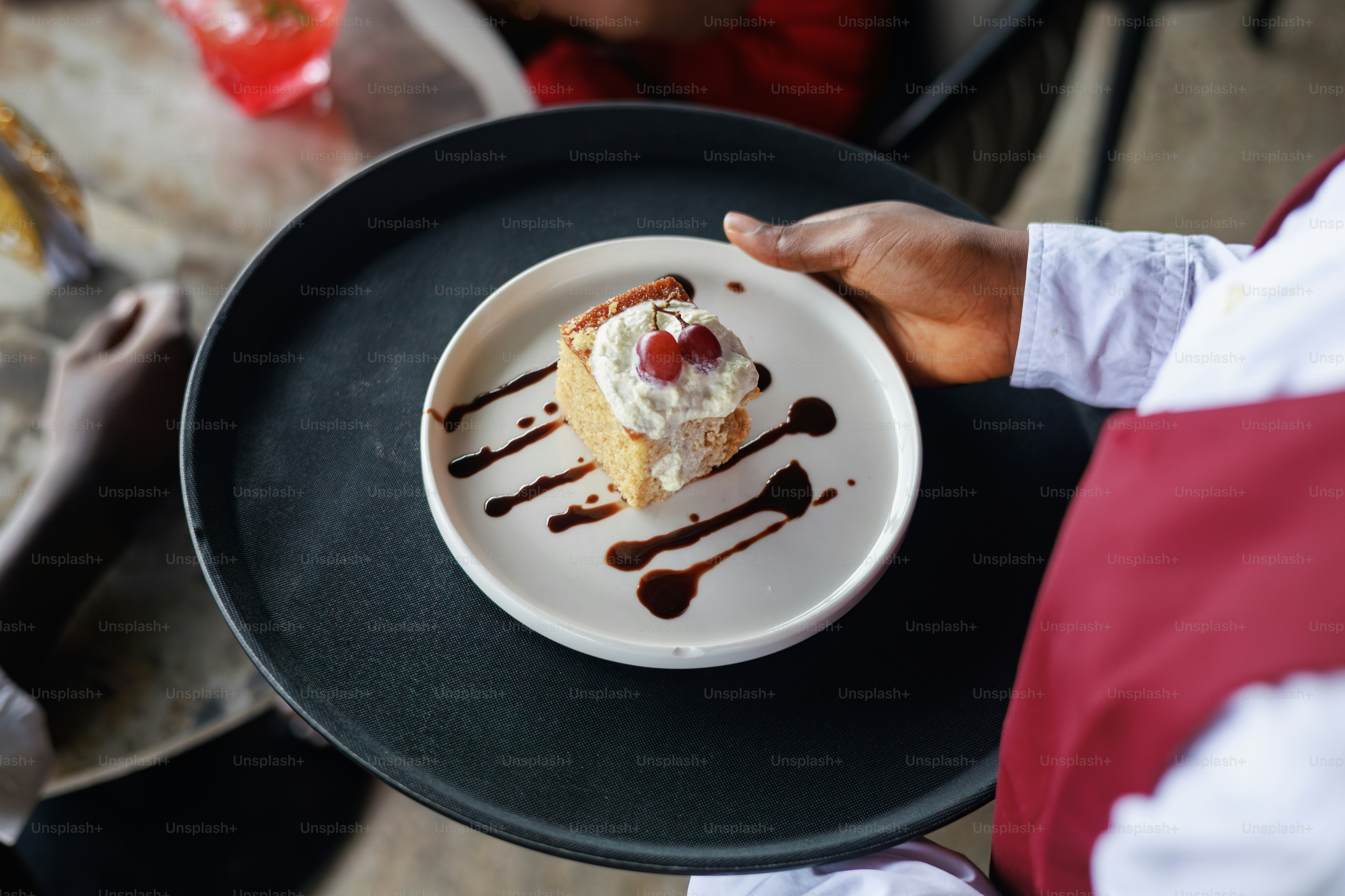 Un camarero sostiene un pastel en una bandeja. foto – Imagen de ...