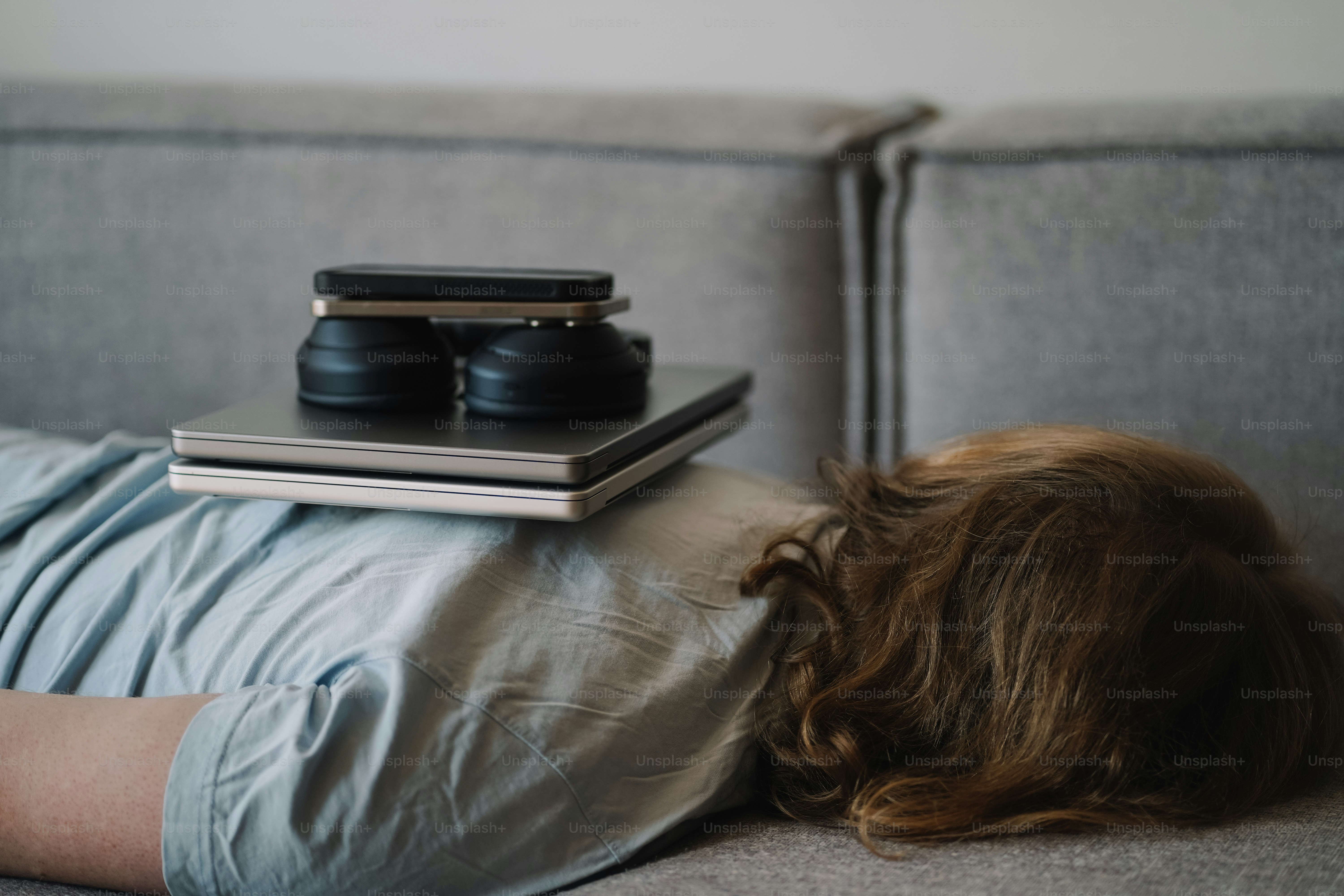 Laptop and headphones balanced on a person.