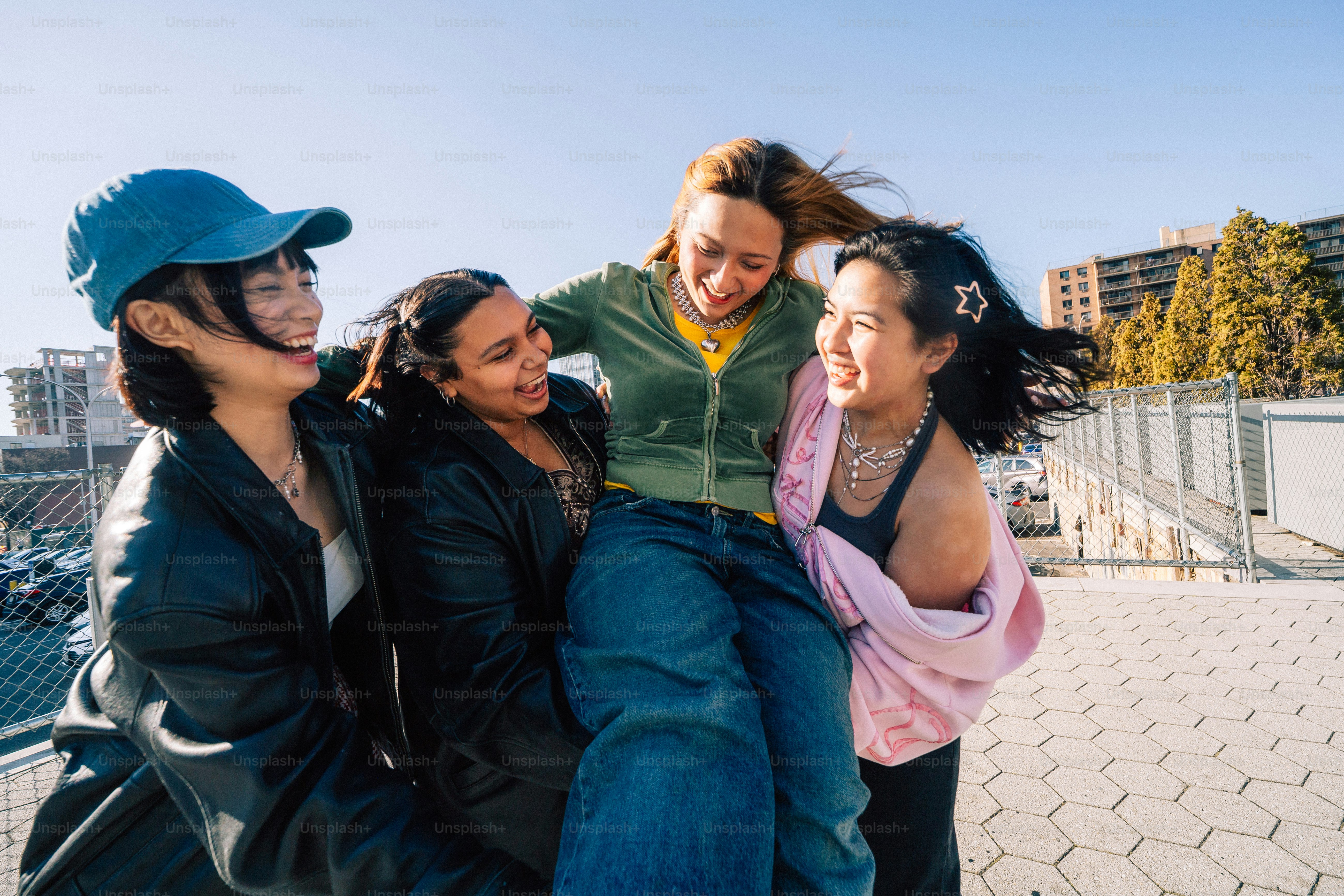 Friends happily lift up their friend.