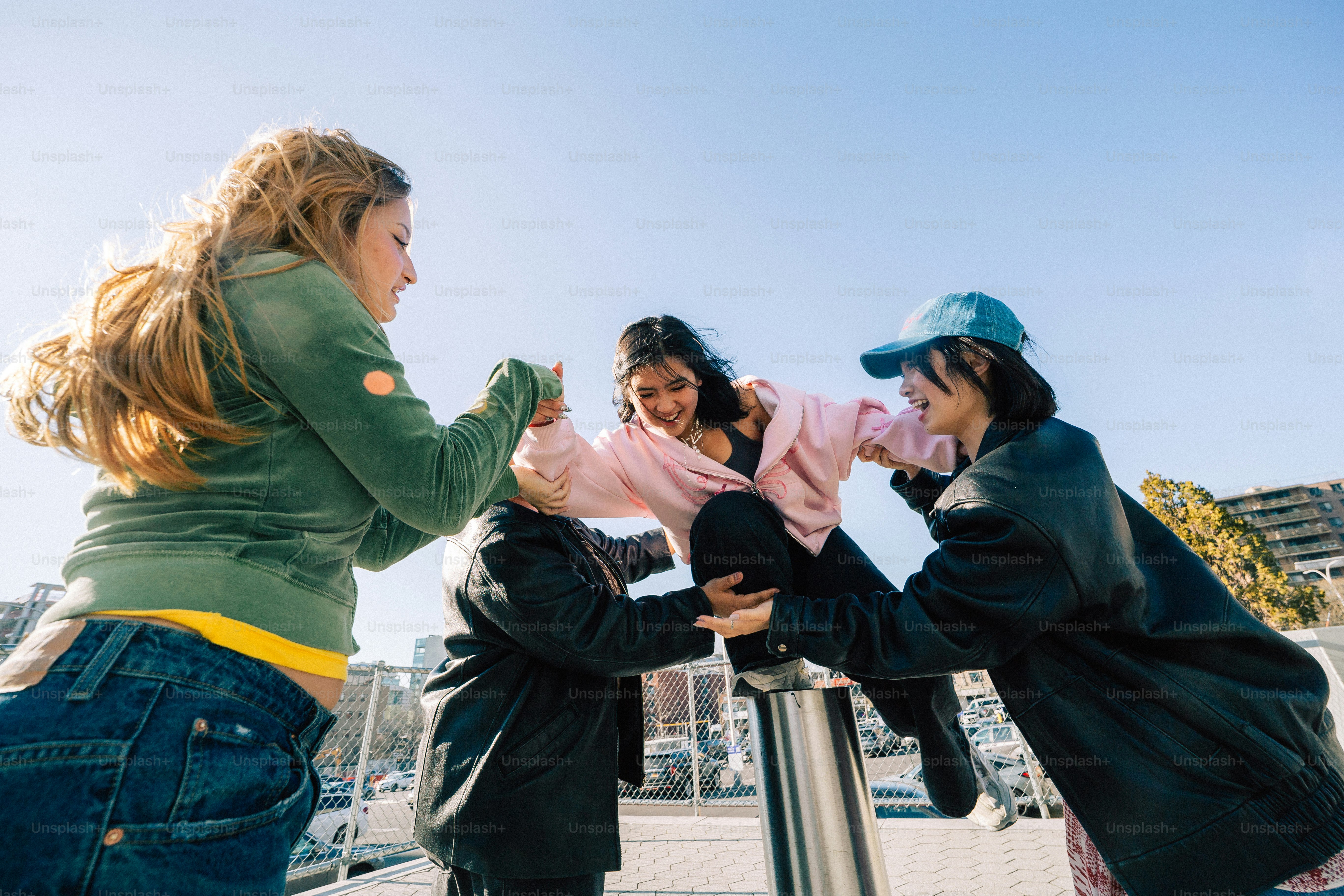 Friends playfully lifting another person outdoors.